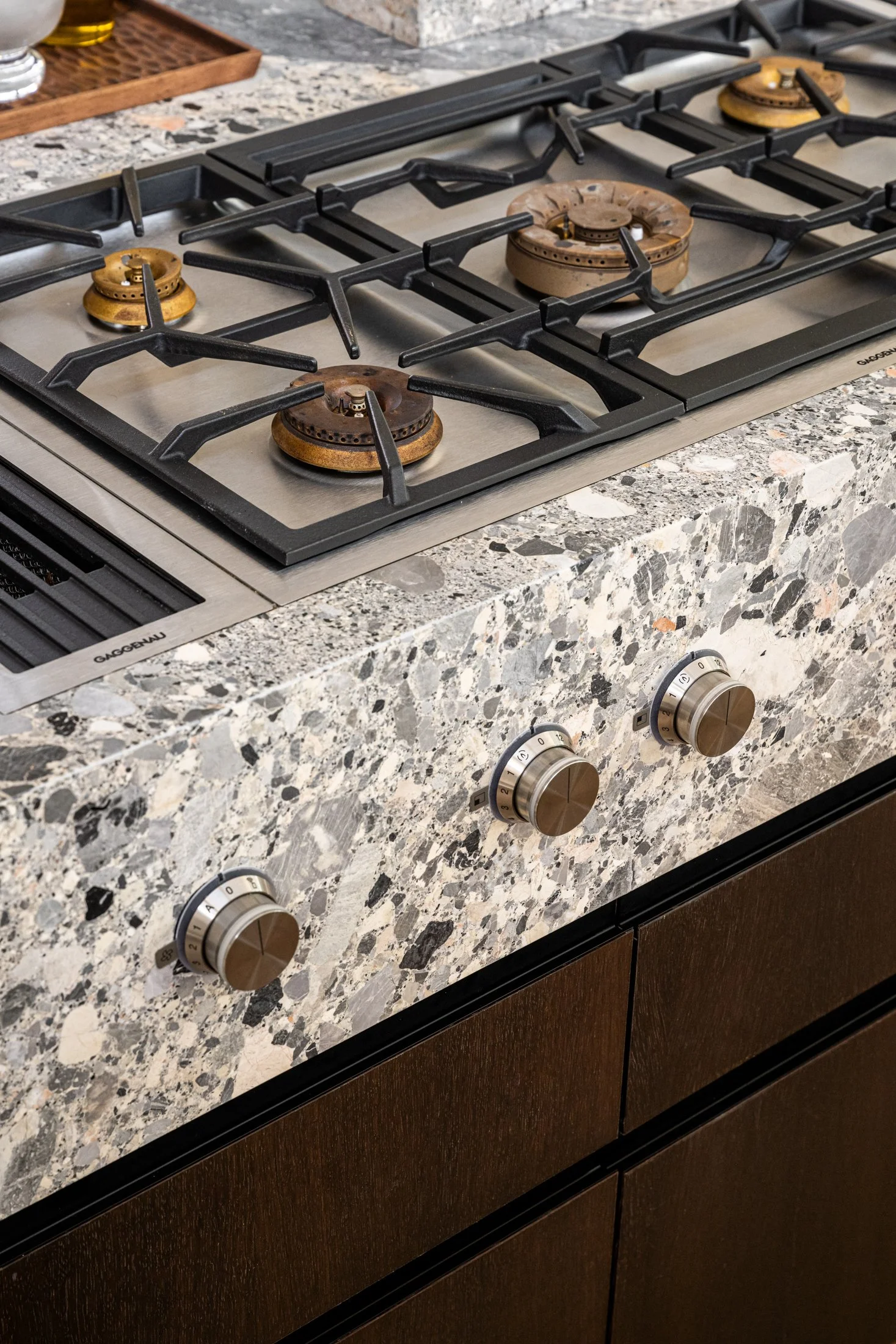 Gaggenau cooktop integrated into ceppo grey marble surface, highlighting precision detailing and material continuity in a modern kitchen.