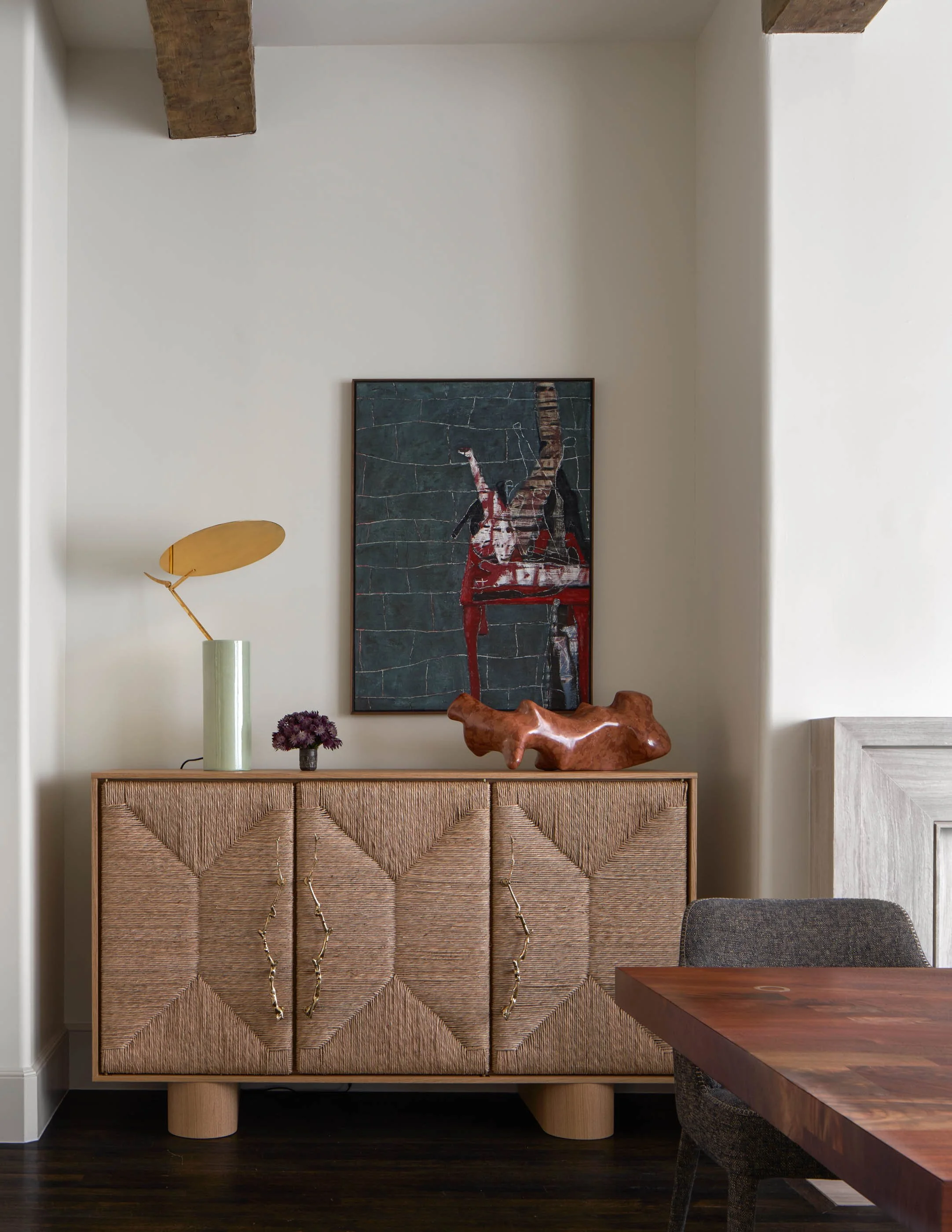 Custom woven cabinet with contemporary art and sculptural objects in masculine modern dining room
