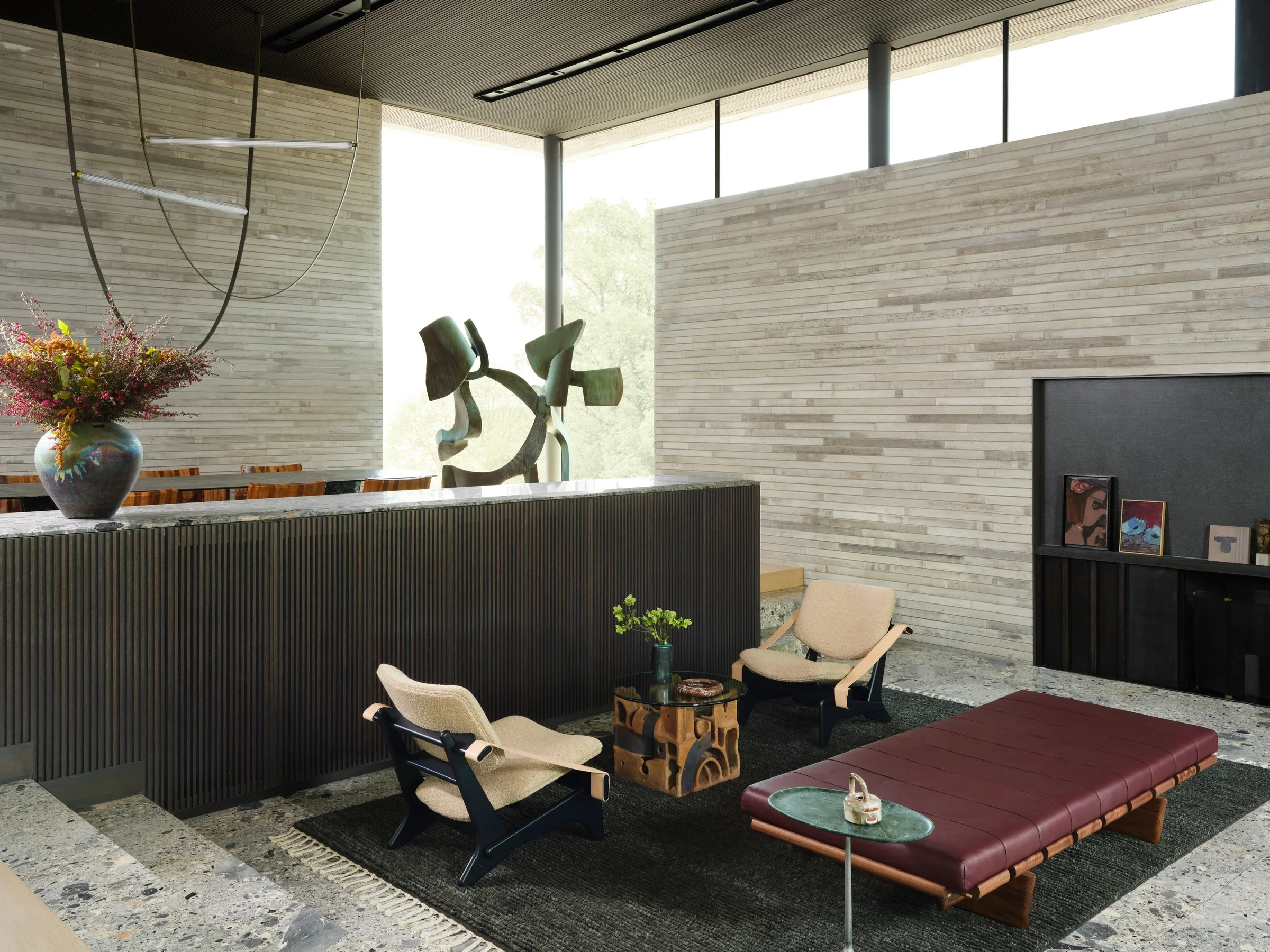 Open-plan living space with sculptural seating, stone flooring, and integrated architecture, centered around curated objects and art.Oxblood Leather and Walnut “BLR” daybed designed by Joshua Rice
Green Marble Side Table by Jader Almeida
Vintage Jumb
