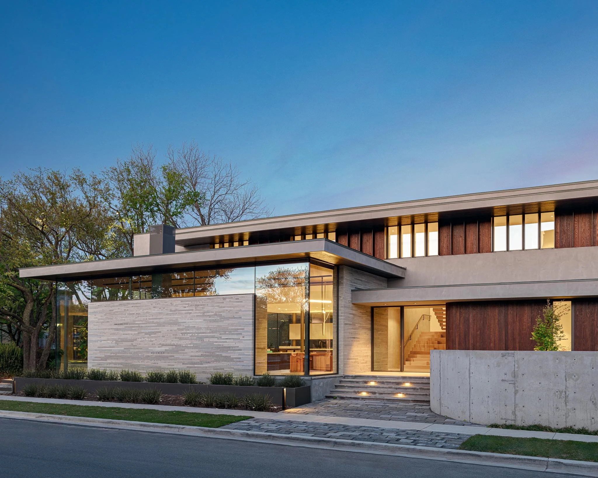 Contemporary residential architecture with layered volumes, glass corner windows, and refined material palette in a modern home design. SmithArc Architects.