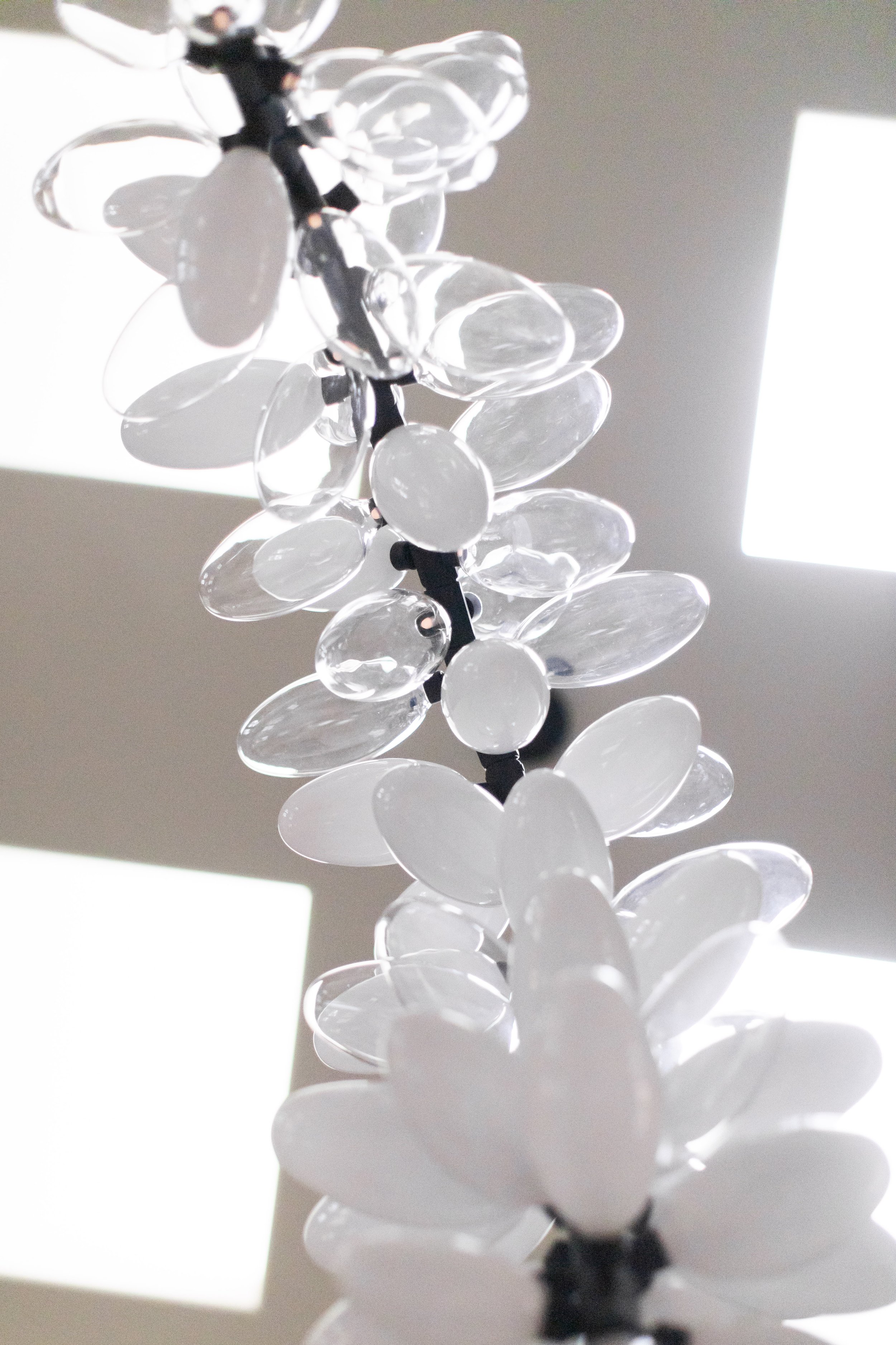 Contemporary glass chandelier with layered oval glass elements forming sculptural lighting fixture lindsay adelman karl zahn