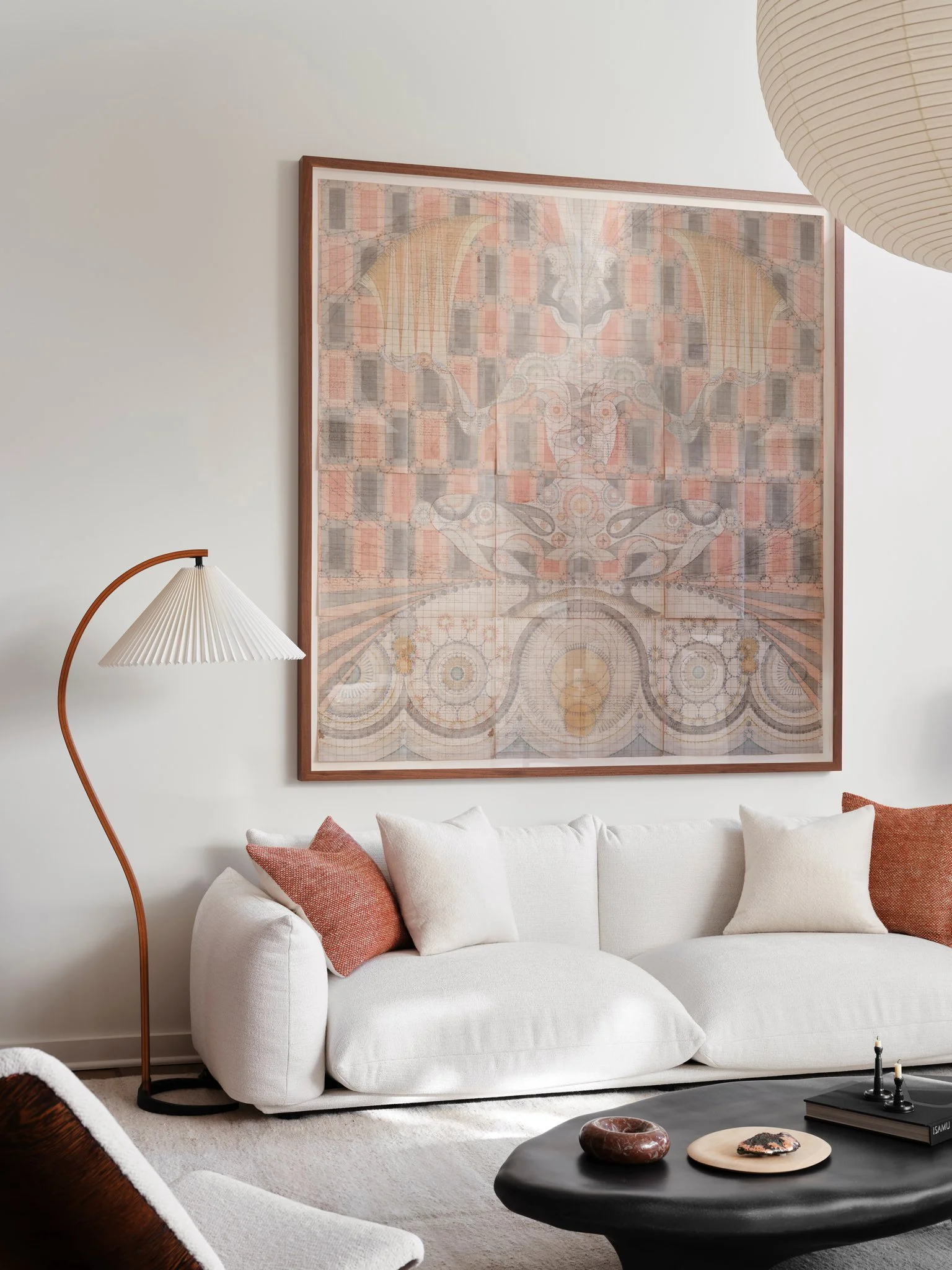 Modern living room with low-profile sofa, large-scale artwork, and sculptural fiberglass coffee table, defined by soft textures and warm neutral tones. Marenco Sofa , design Mario Marenco.  Chair by Theo Ruth in the Foreground.