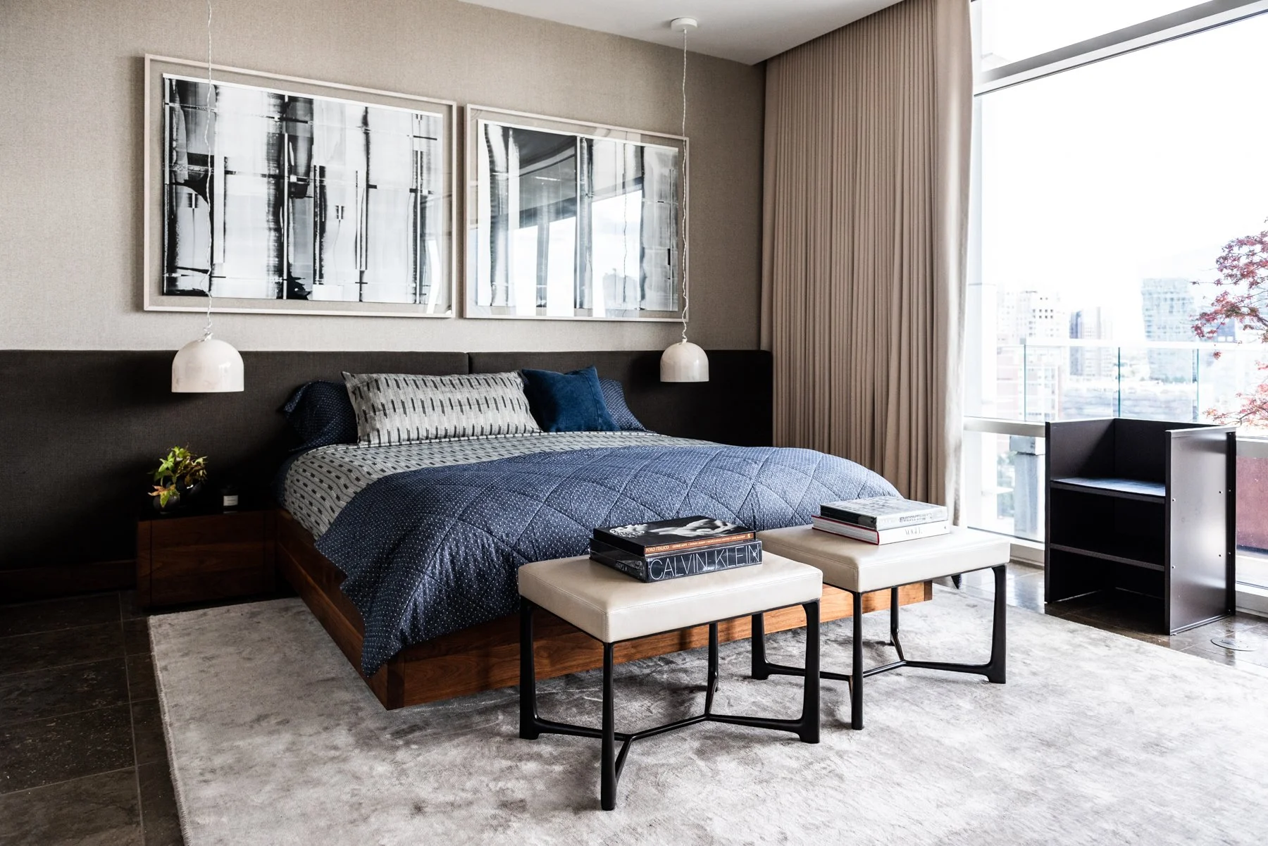 Warm modern bedroom with wood platform bed, upholstered headboard, pendant lighting, and city views donald judd furniture, mark williams artist, benjamin Hubert