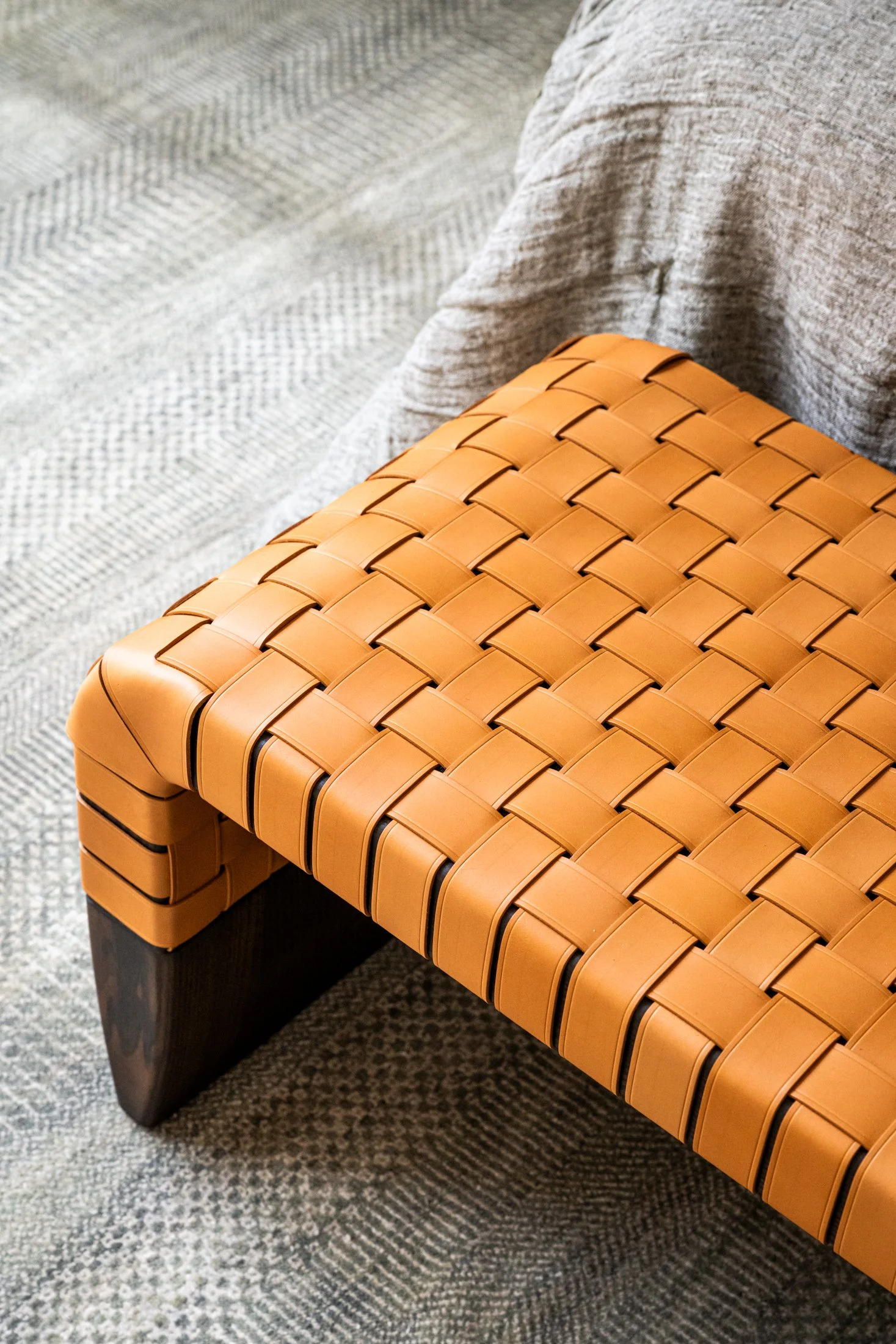 Woven leather bench detail showcasing craftsmanship, texture, and warm tonal contrast in a modern luxury interior. Bench in room by ‘Brera’ by Guglielmo Ulrich for Poltrona Frau