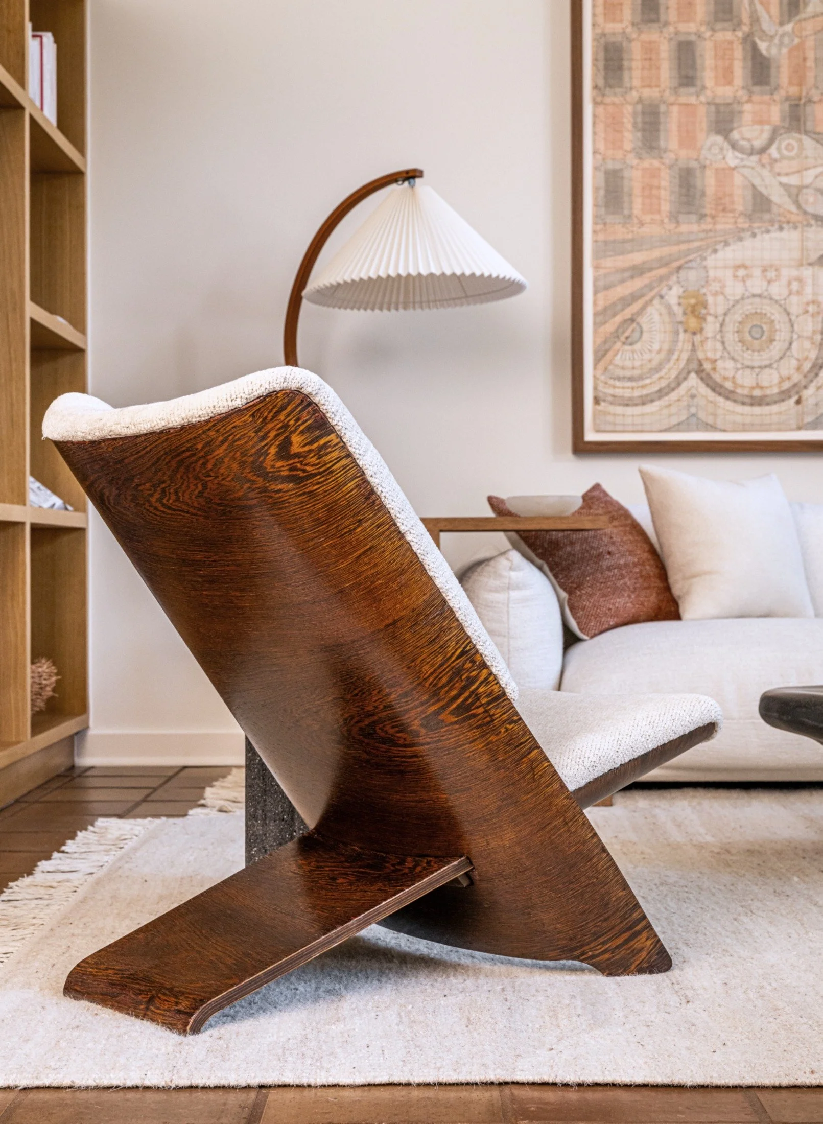 Sculptural wenge wood prototype lounge chair by Theo Ruth with upholstered seat in a modern living room, paired with soft textiles and curated artwork. Marenco Sofa, design Mario Marenco.