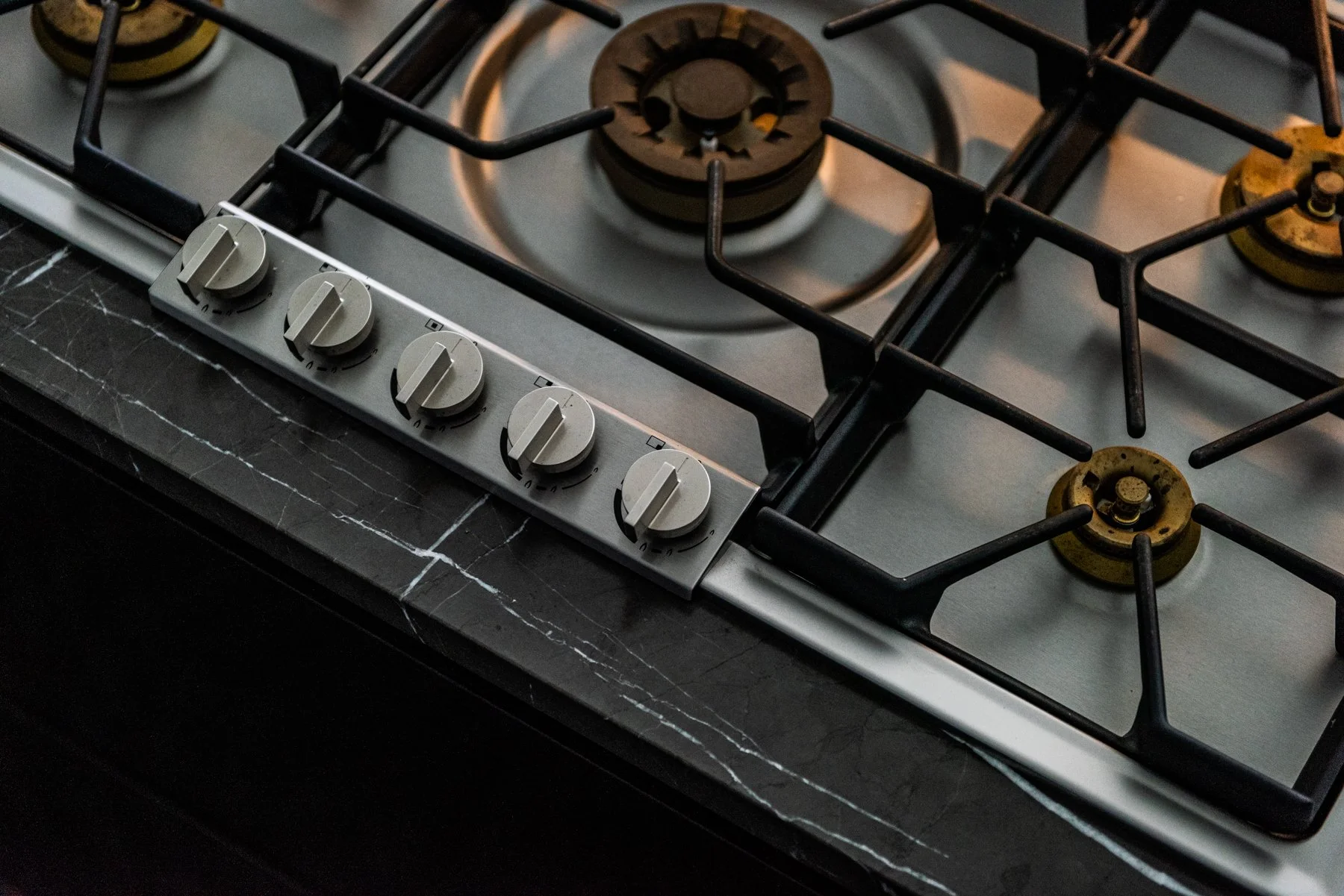 gaggenau Professional gas cooktop with brushed steel controls set into dark marble countertop