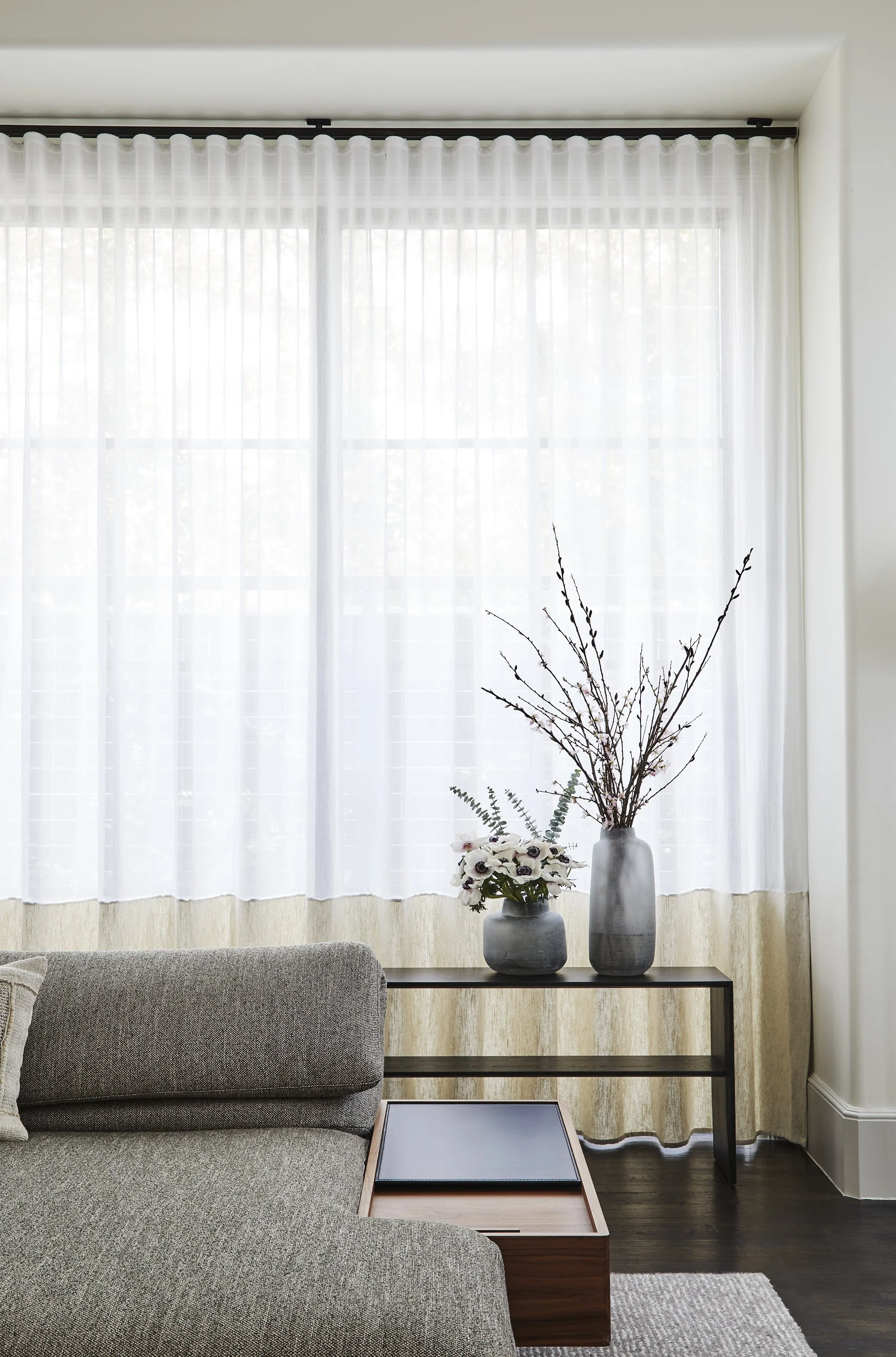 Modern living room console with ceramic vases and sheer linen curtains in luxury residential interior