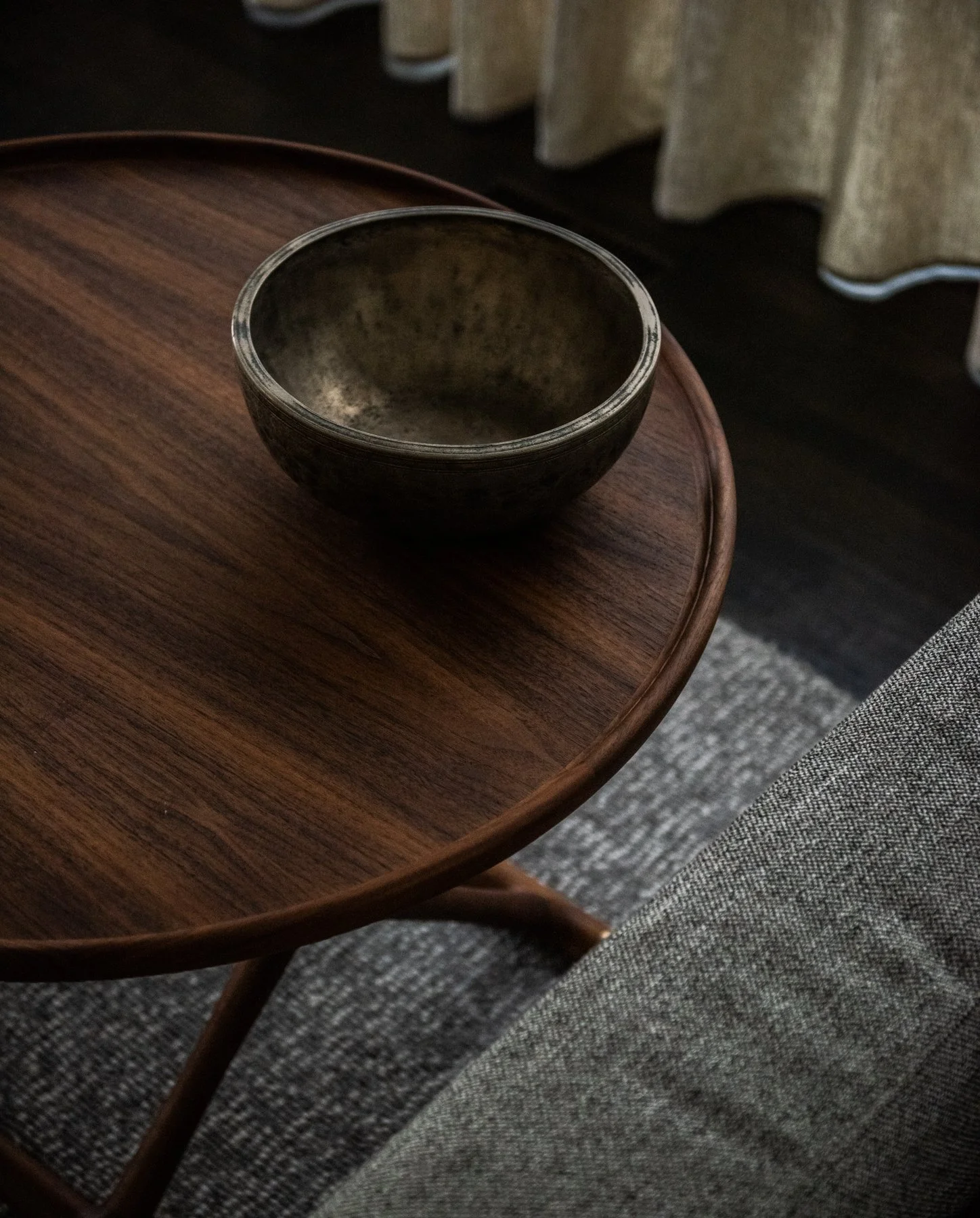 Modern sitting room with sculptural lounge chairs, round table, plaster fireplace, and neutral textures mogens koch table brass bowl