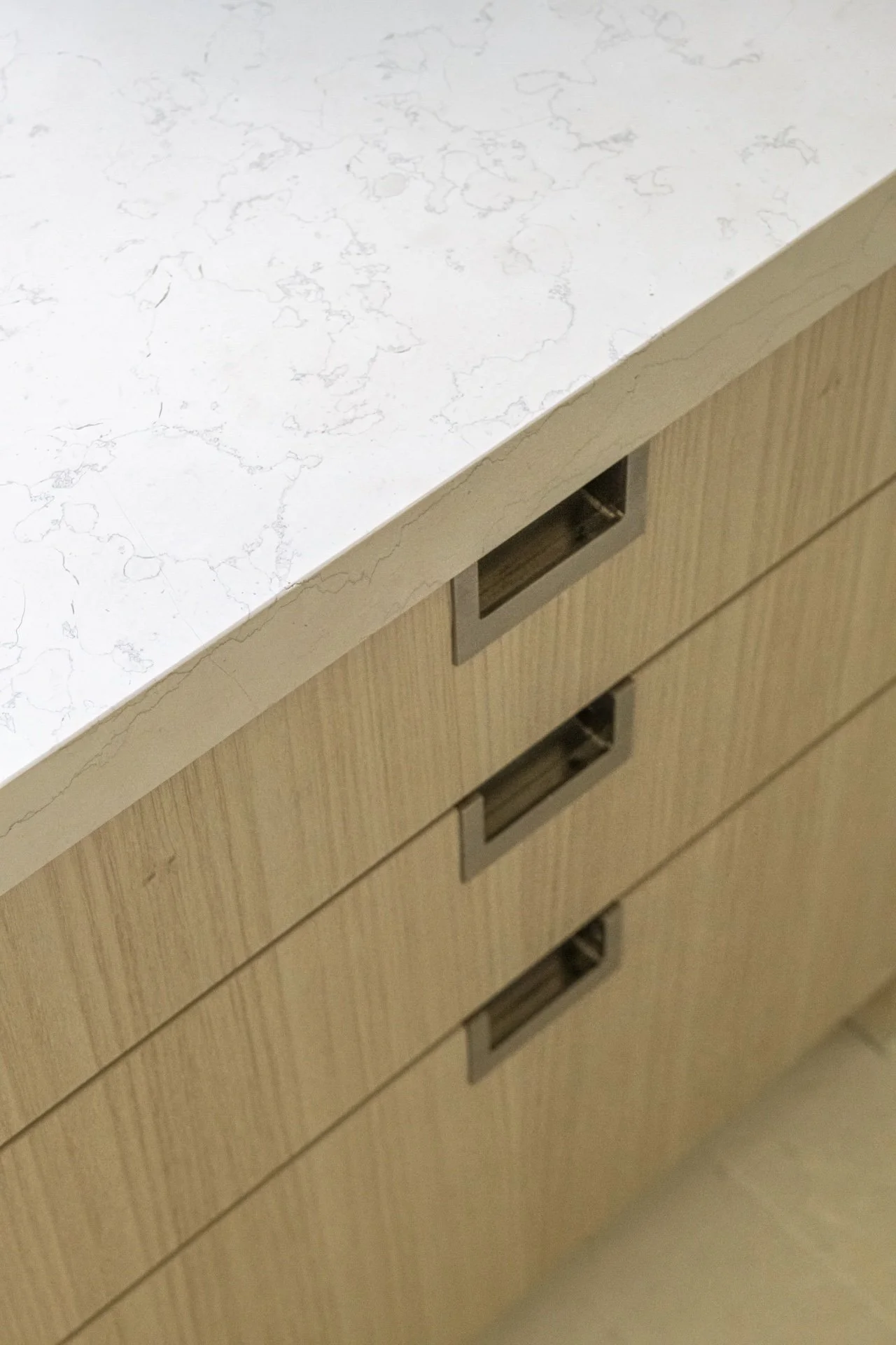 Custom wood bathroom vanity with stone countertop, integrated pulls, and tailored millwork showcasing quiet luxury residential design.