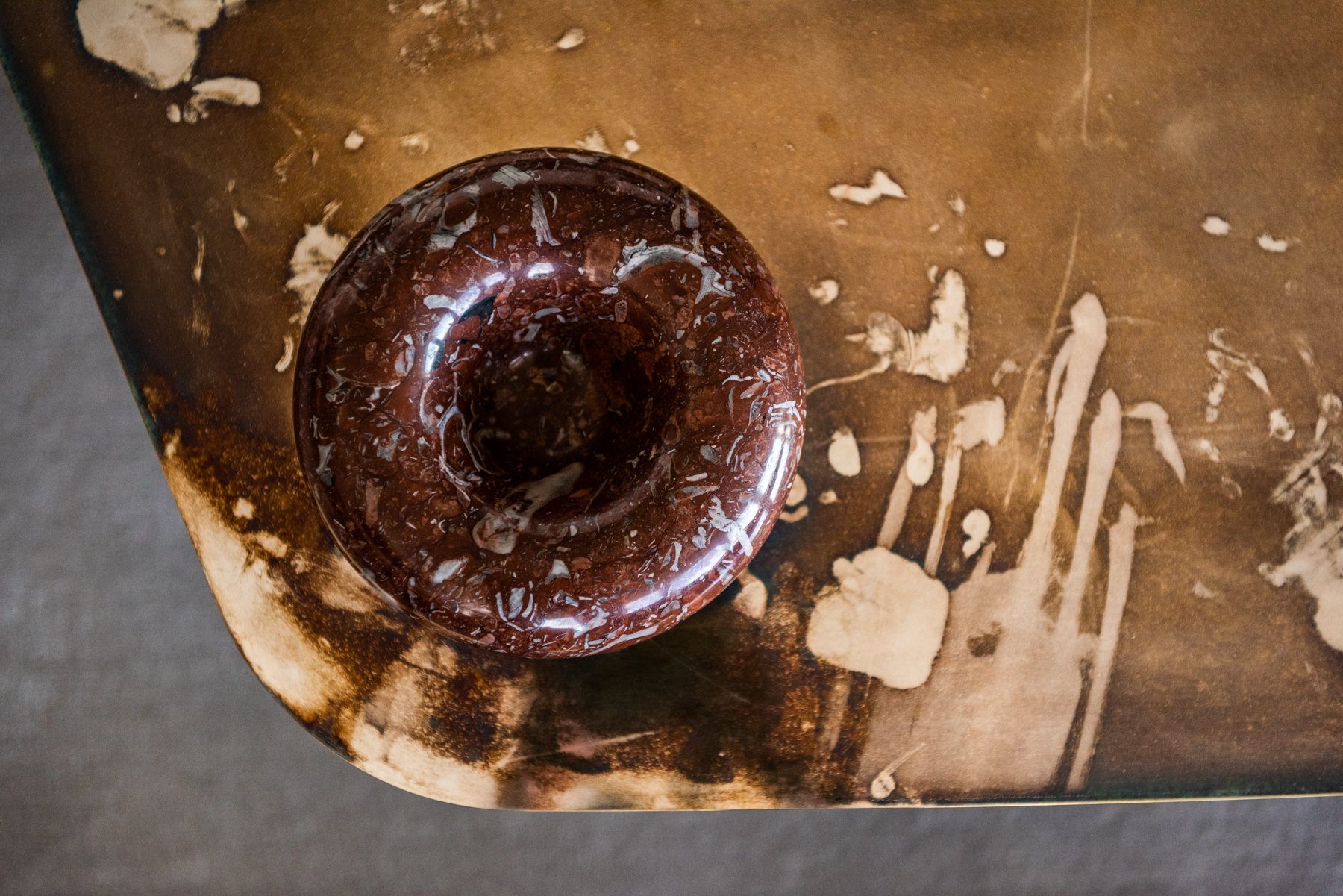 Highly Collectable coffee table with sculptural metal surface silvered brass, leather desk pad, and curated design books in contemporary living room. vincenzo de cotiis , progetto domestico, sergio asti marble bowl