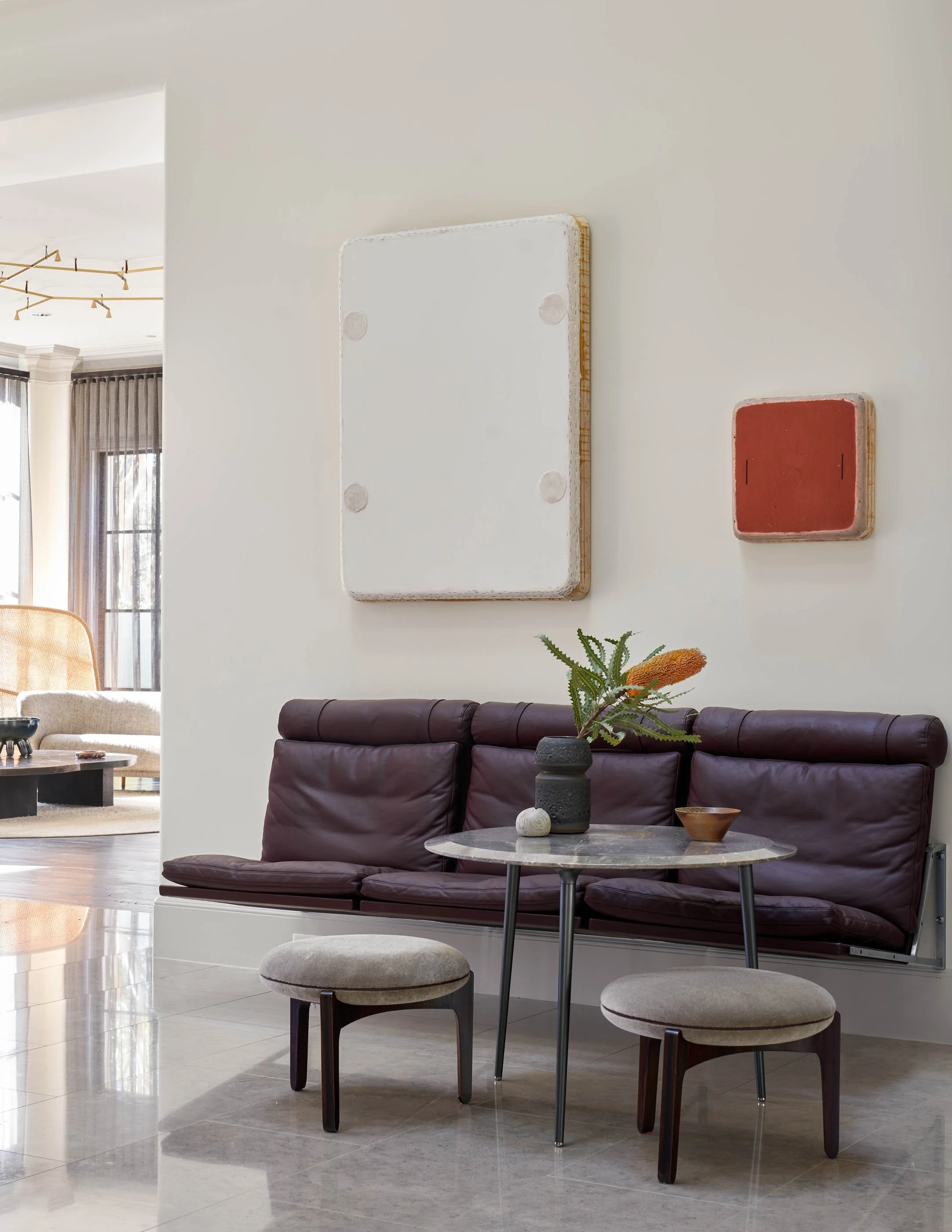 Unique interior seating area with leather sofa, marble table, and contemporary wall art otis jones fabricius kastholm wall mount sofa