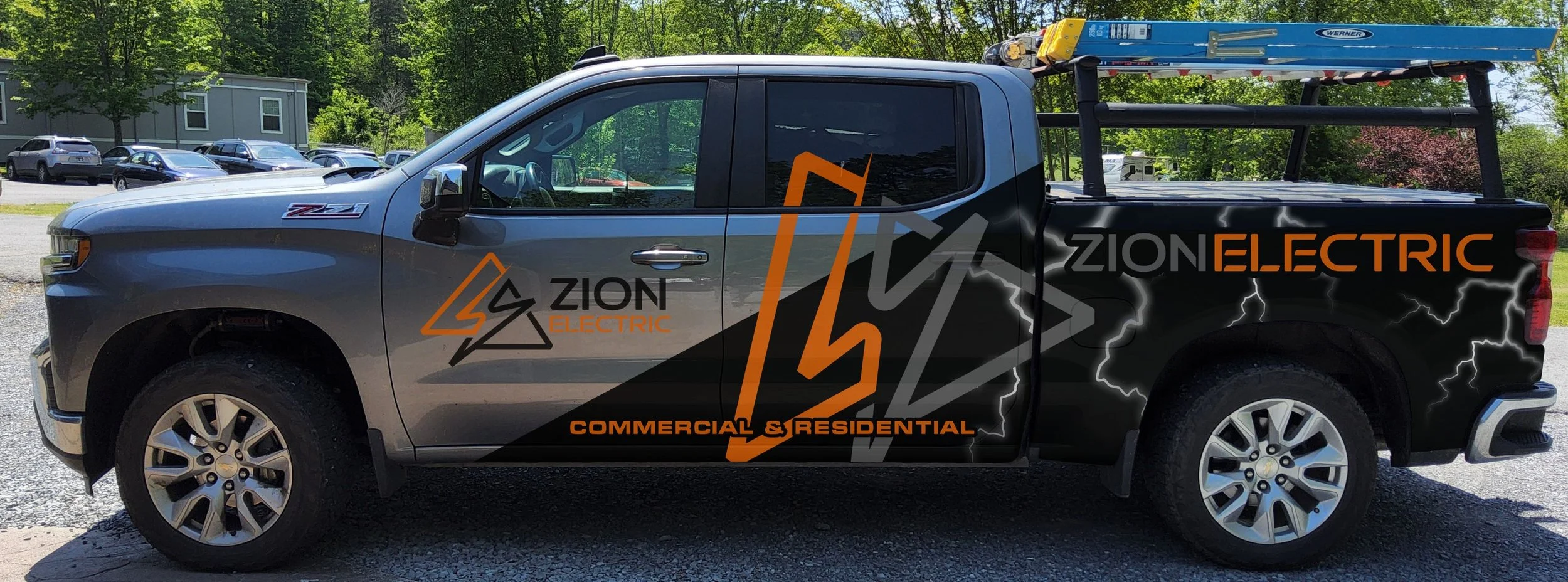 Person wearing a gray cap and khaki shirt, with a logo, looking into a plastic orange storage container filled with boxed and packaged products on a wood floor.