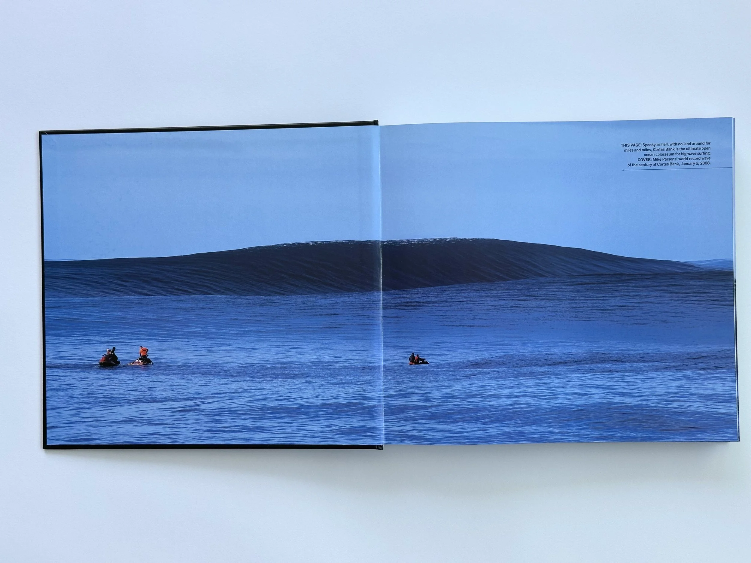 Pages within Pacific Quests book. Features surfers with a large wave in the background.