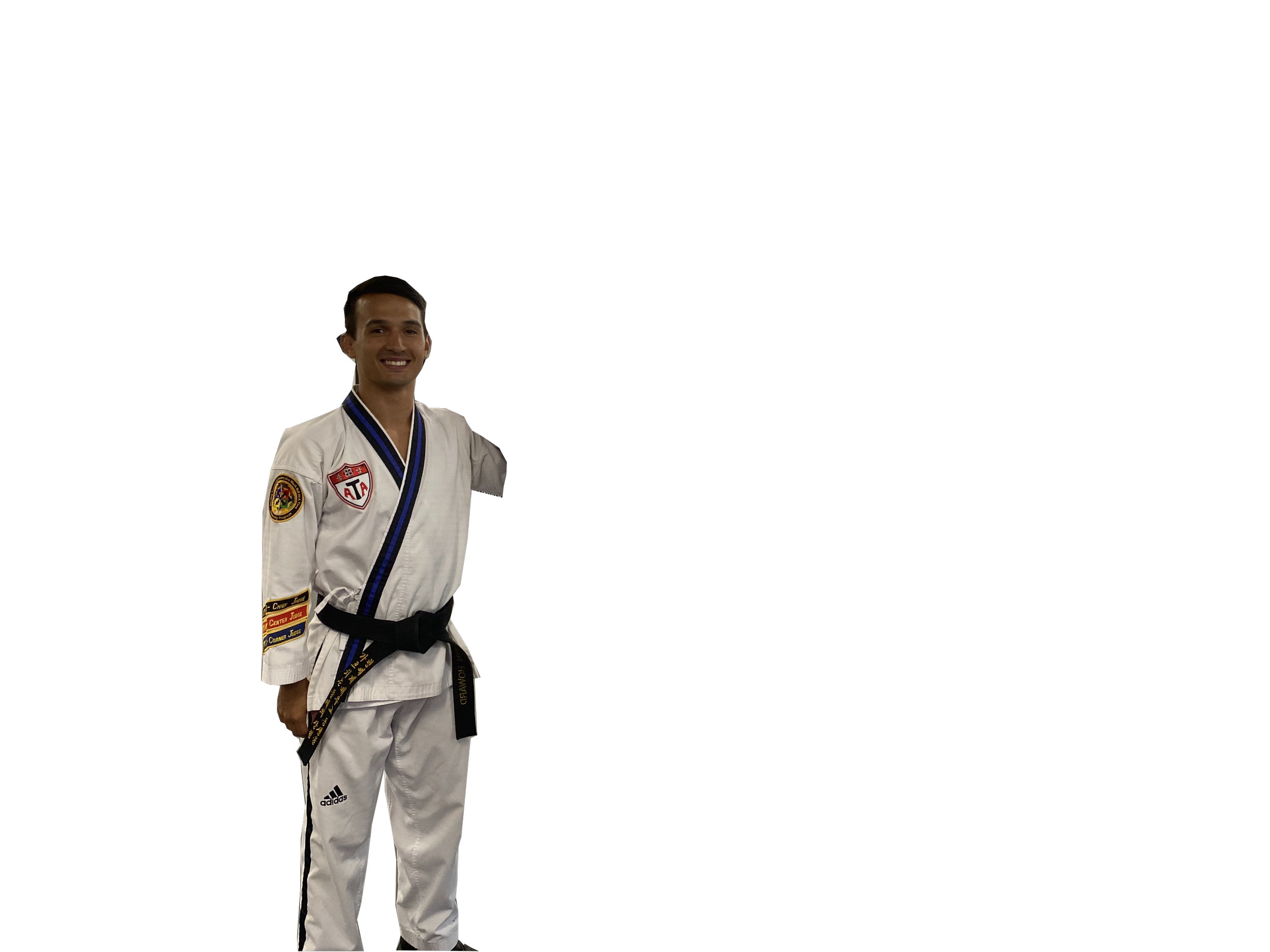 A young man in a white martial arts uniform with black belt, smiling, standing against a black background.