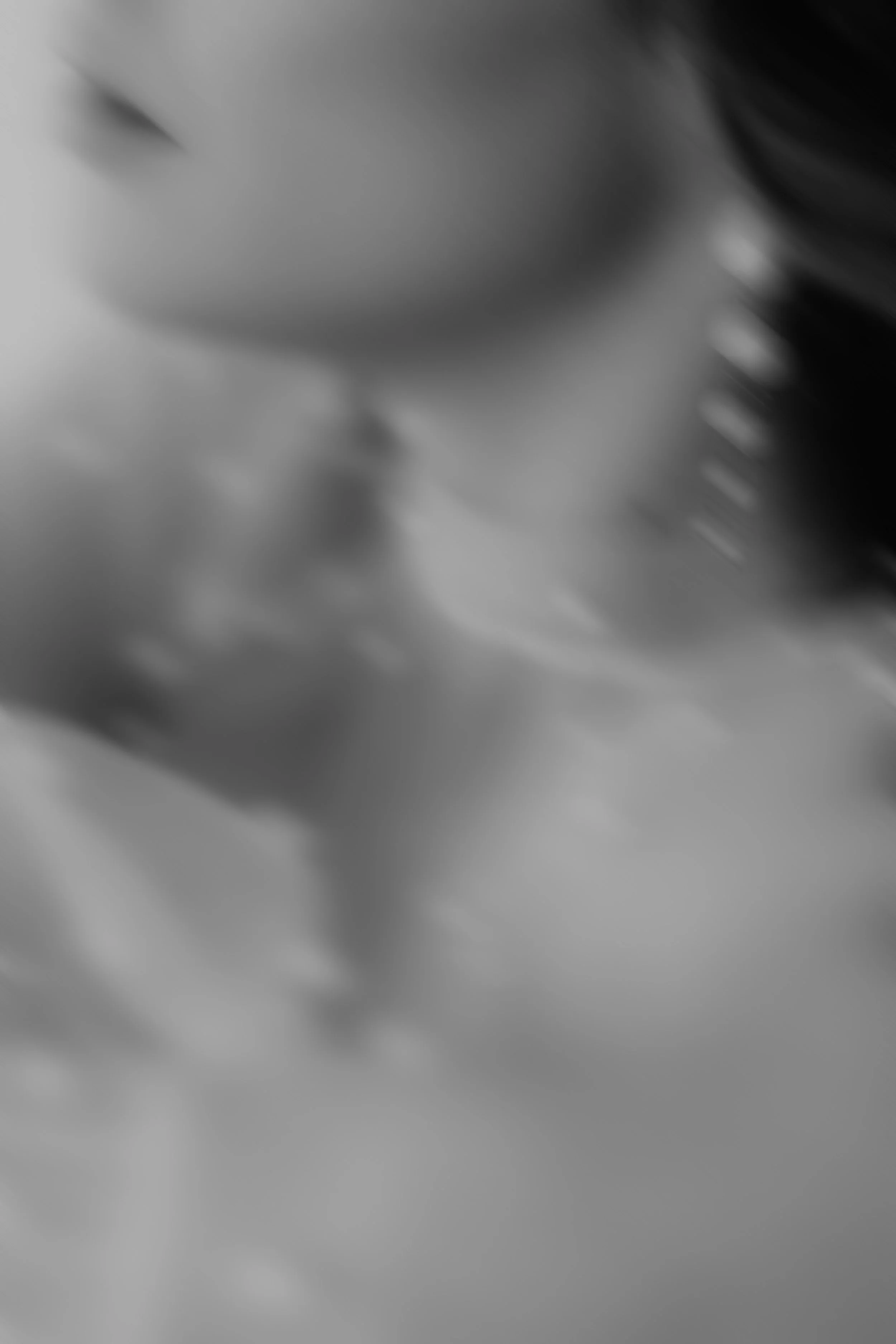 Das Bild ist unscharf und in Schwarz-Weiß, zeigt aber eine Nahaufnahme einer menschlichen Hand, die eine andere Hand berührt oder hält.