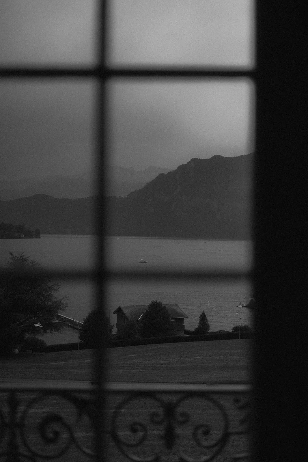 blick auf die Landschaft mit Berg, Wasser und Häuser, sichtbar durch Gitterfenster der St Charles Hall in Schwarz-Weiß