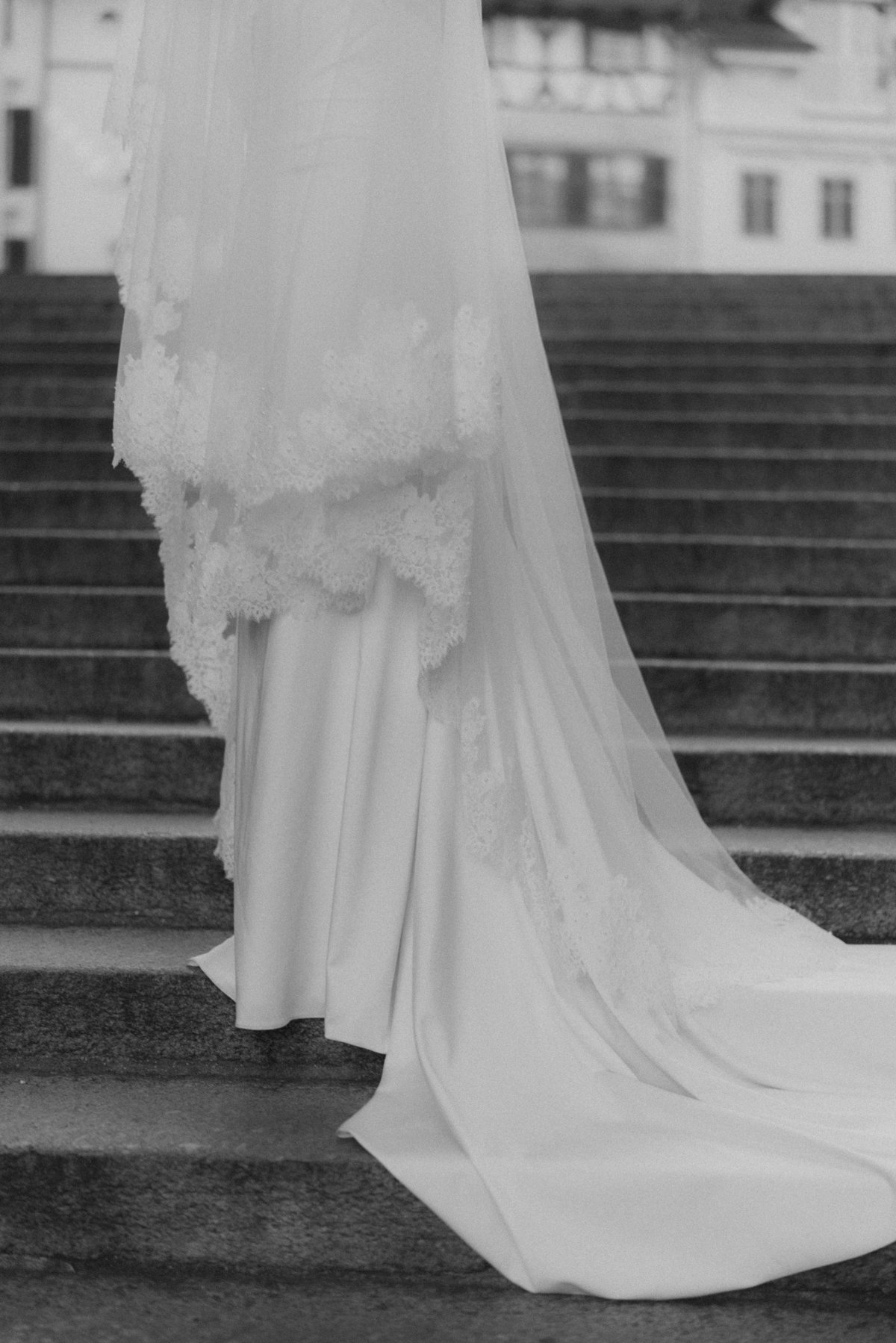 Ein Brautkleid auf einer Treppe. Das Kleid ist lang und hat einen Schleier.