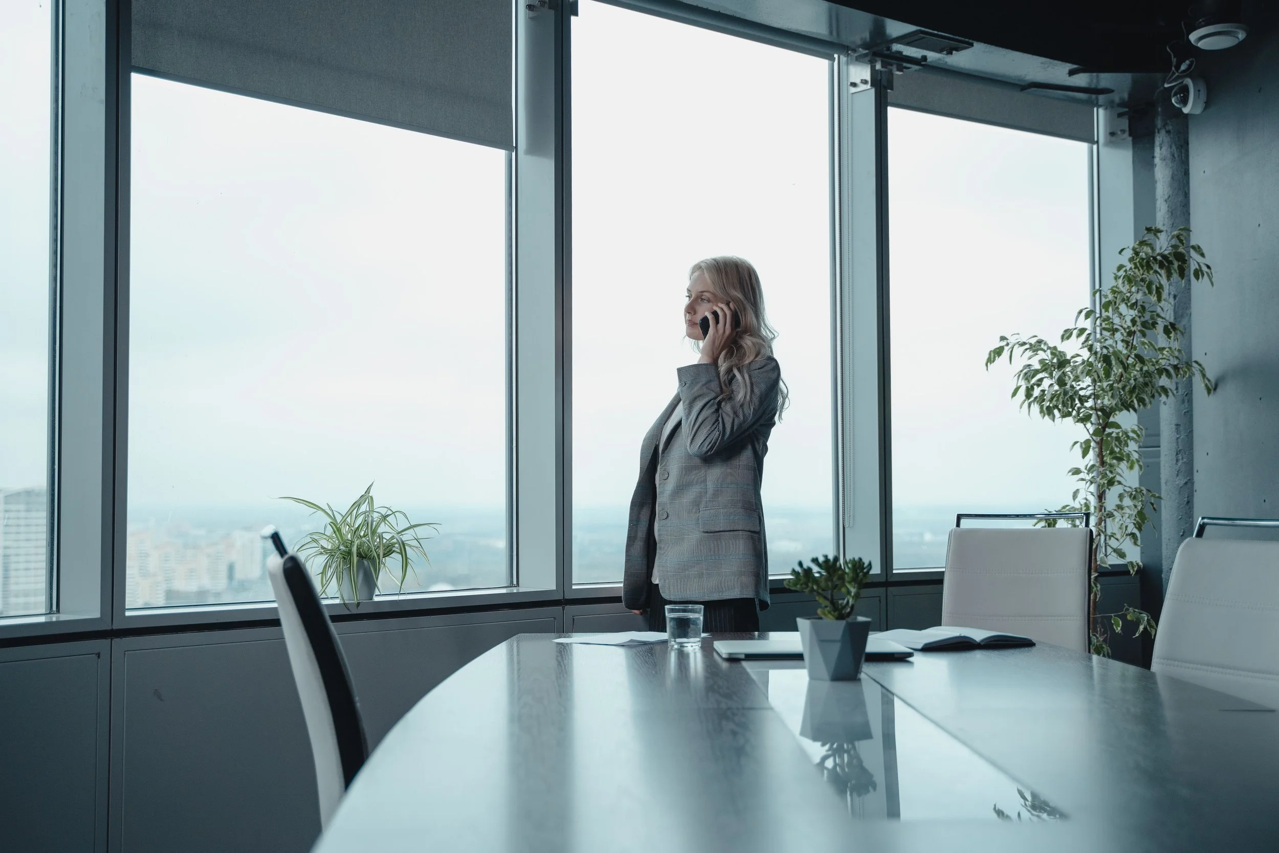 female executive on the phone looking out of a skyscraper