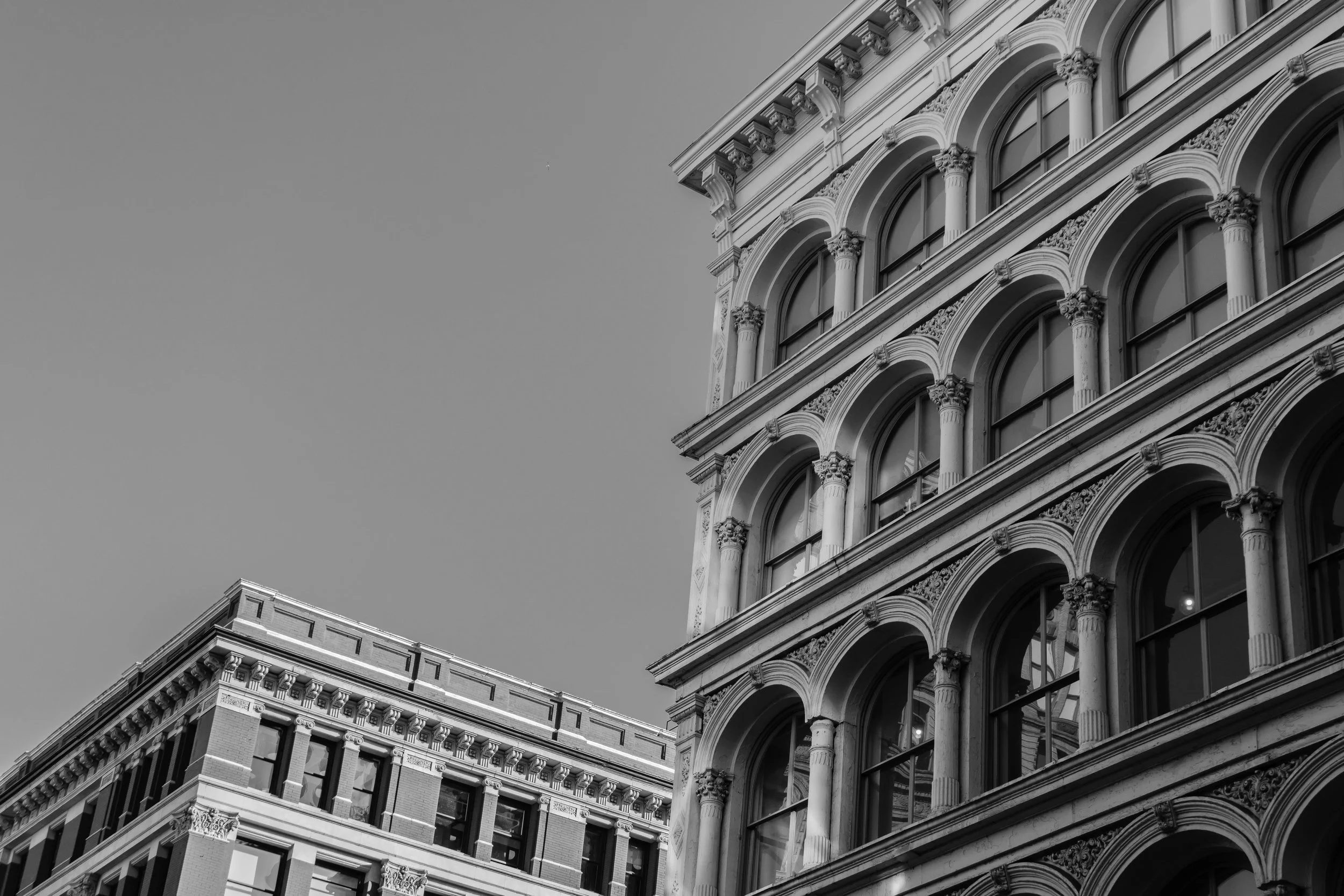 Black and white photo of historic architecture with ornate windows and columns.