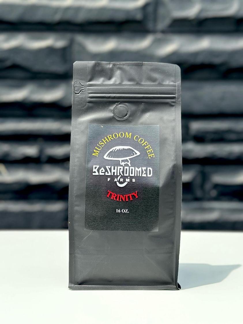A black package of mushroom flavored coffee labeled 'Mushroom Coffee Beaches Farms Trinity 16 oz.'
