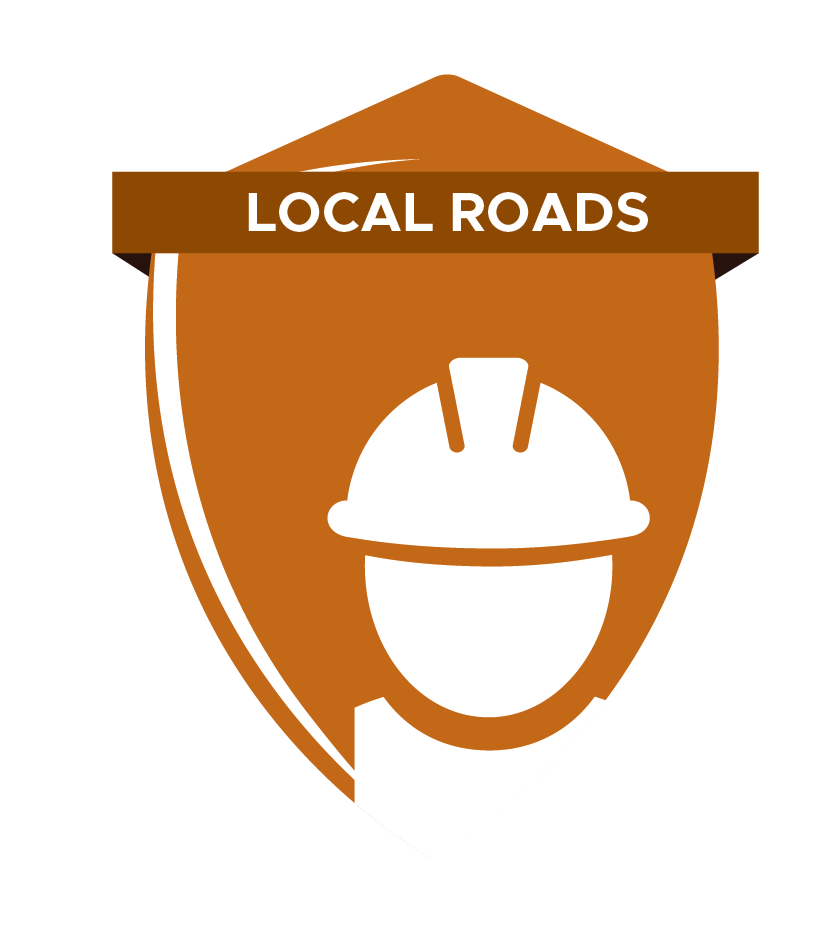 A brown shield-shaped emblem with the words 'Local Roads' on a banner at the top, featuring a white construction helmet in the center.