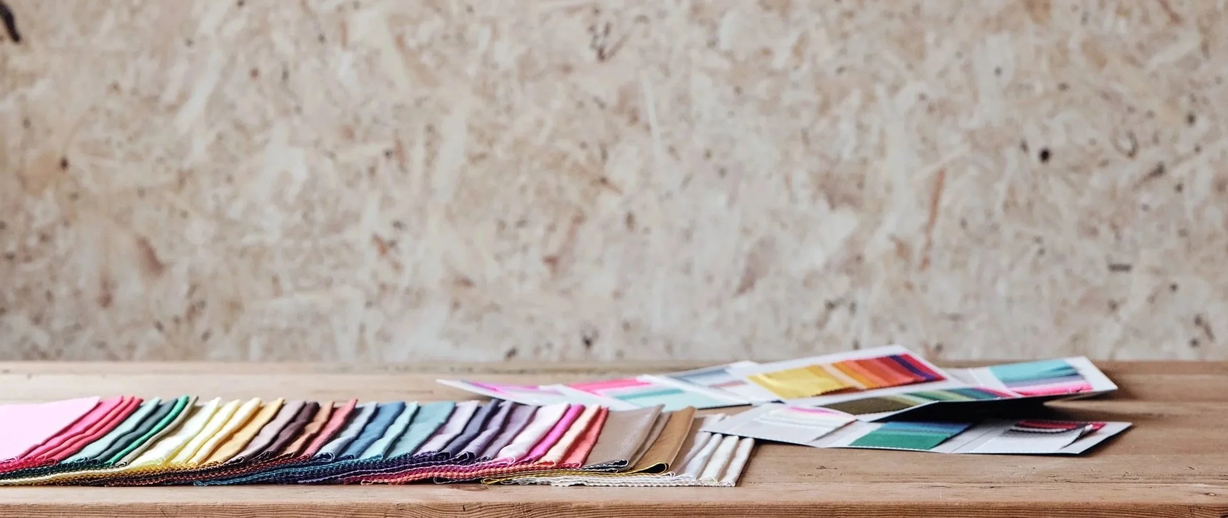 Color swatches and paint sample cards on a wooden surface.