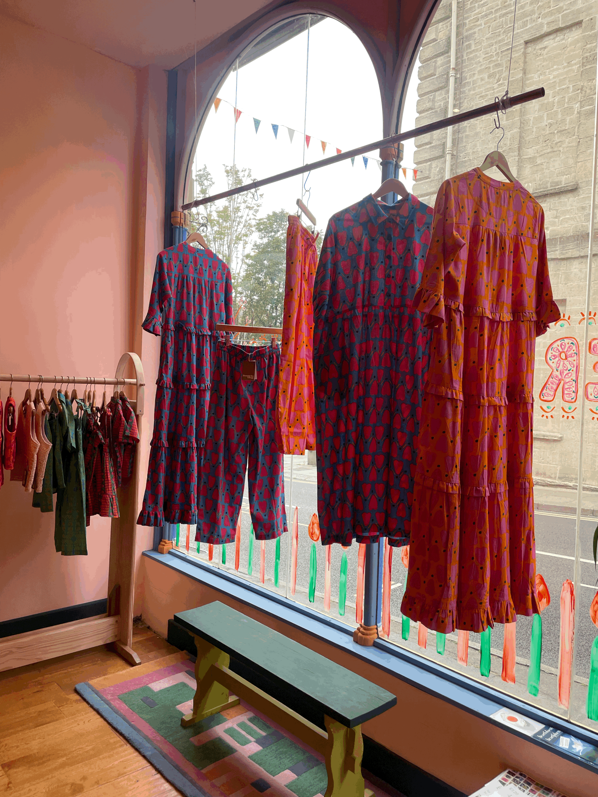 A window display of colourful, hand printed dresses from a personal shopping session.