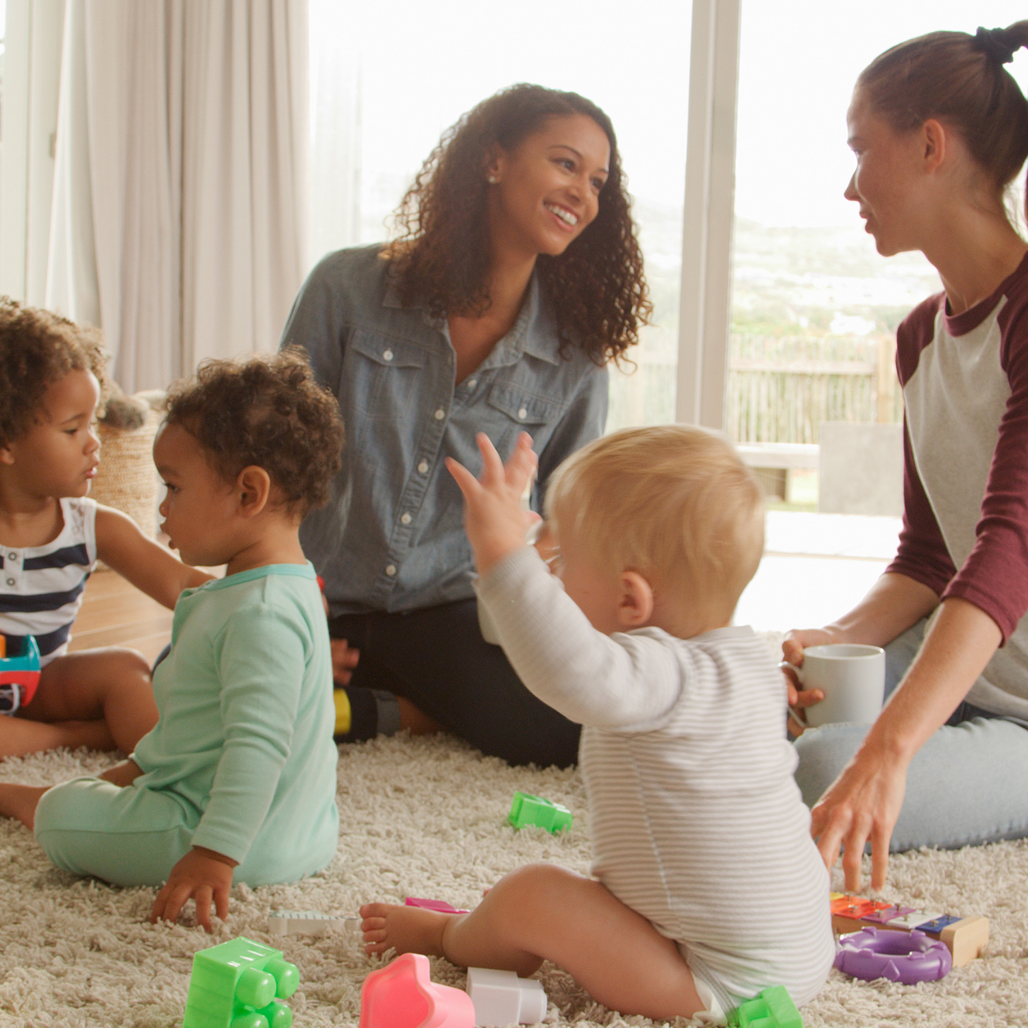 deux jeunes mamans discutant entourées de leurs enfants