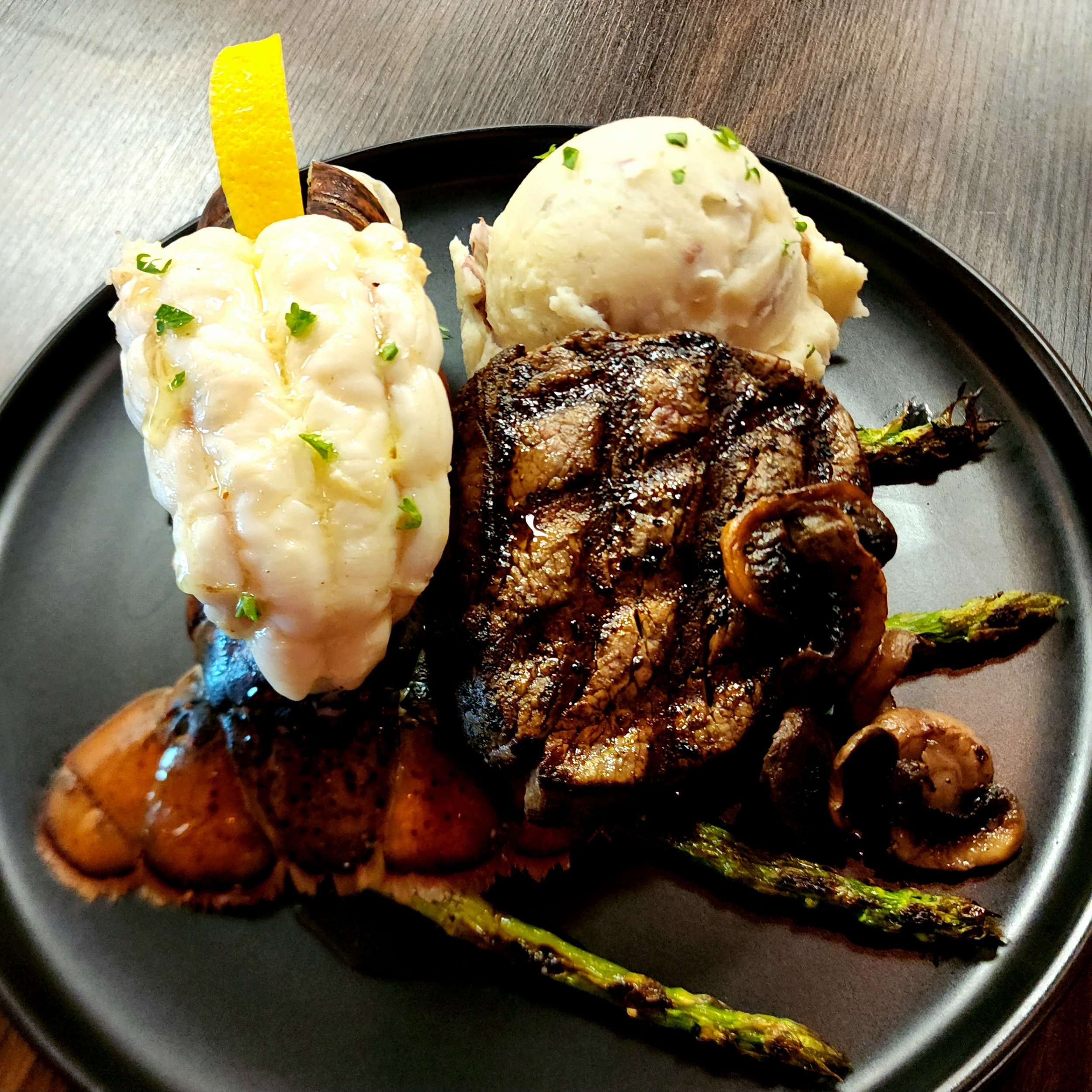 6oz Filet Mignon, 6oz Butter Poached Lobster Tail, & Two Sides.