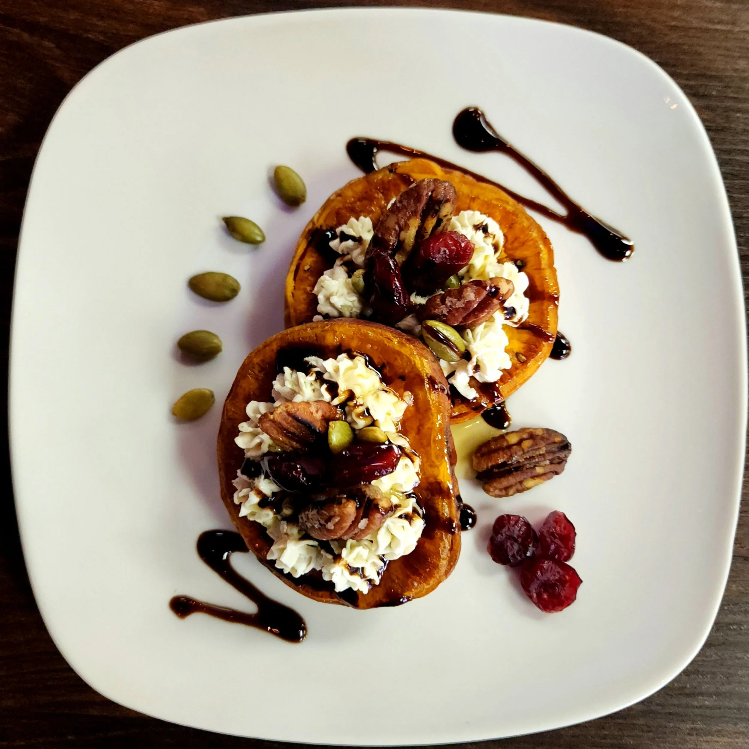 Roasted Sweet Potato Rounds with Goat Cheese, Toasted Pecan, Pepita, & Balsamic Reduction.