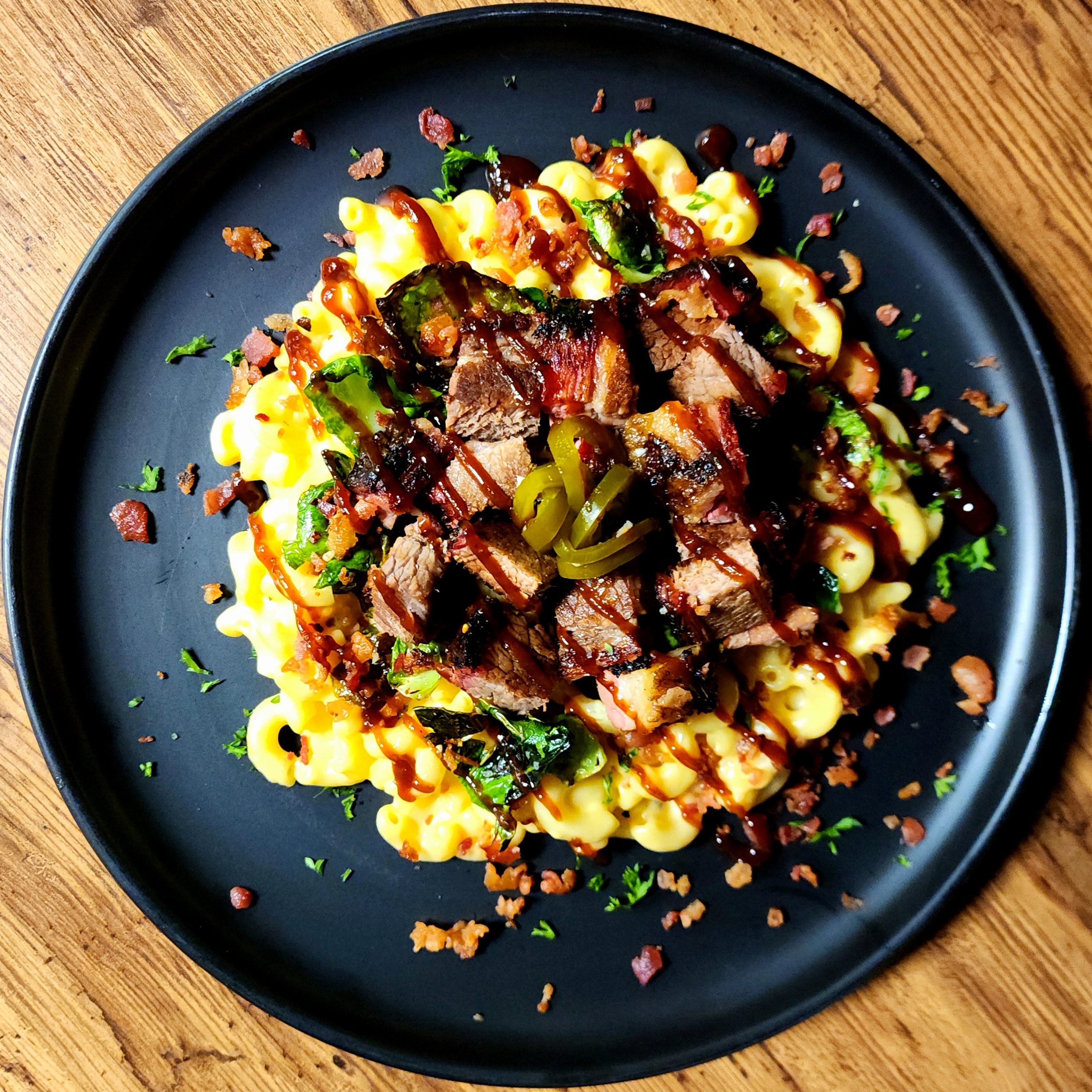 Brisket Mac with Crispy Brussel Petals, Applewood Bacon, & House Pickled Jalapenos. 