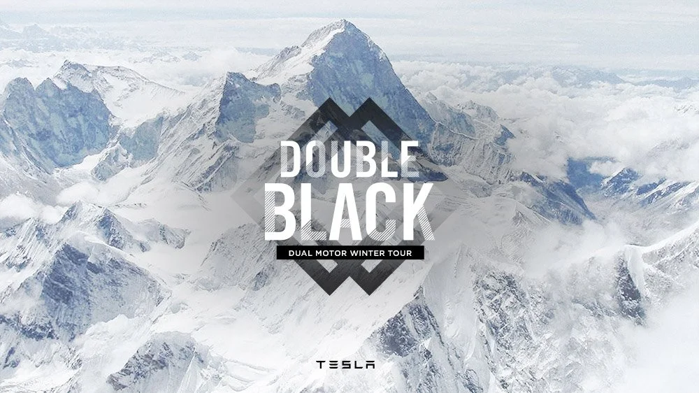 Snow-covered mountain peaks with the text "Double Black" and "Dual Motor Winter Tour" overlaid, along with the Tesla logo.