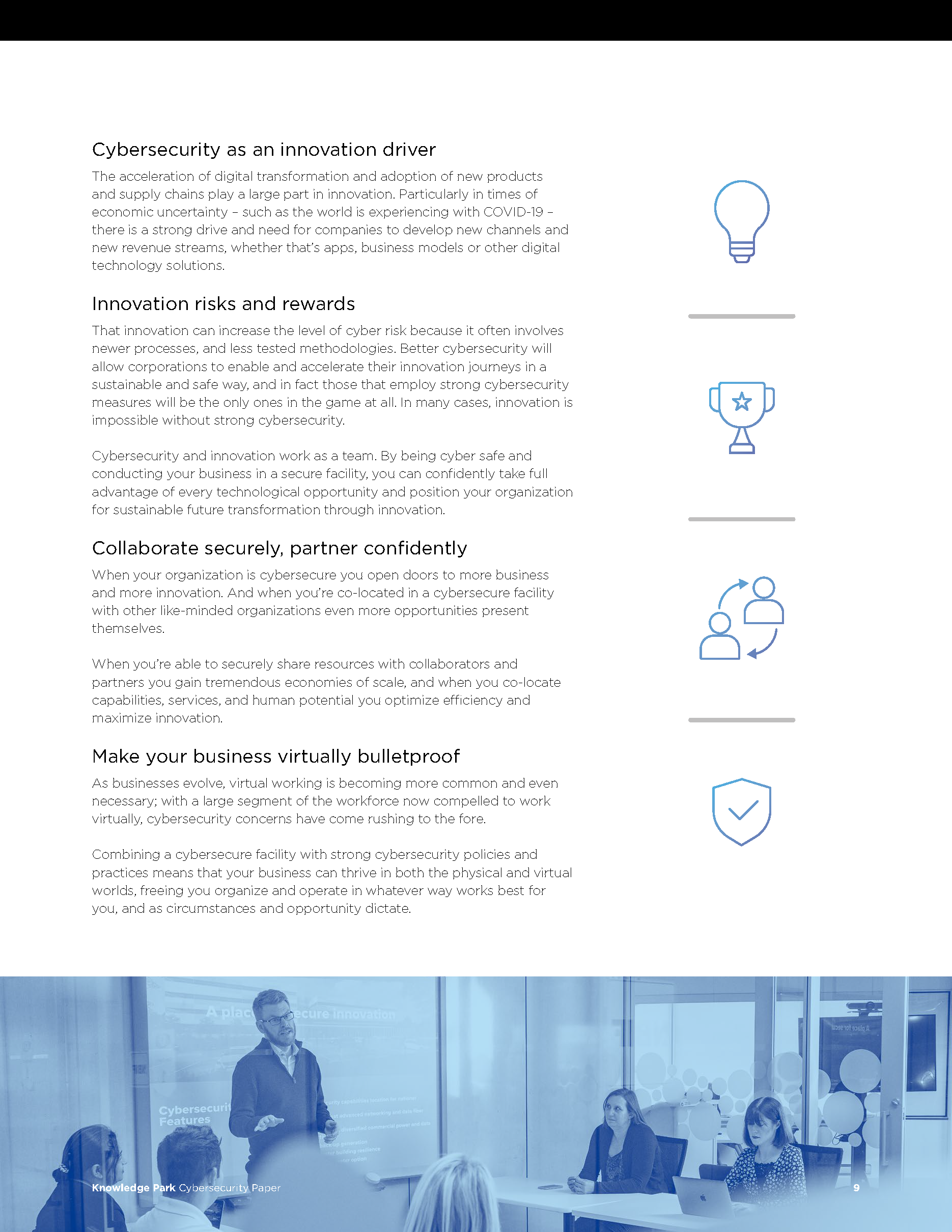 A meeting room with a presenter at the front and four women seated around a table, during a presentation on cybersecurity.