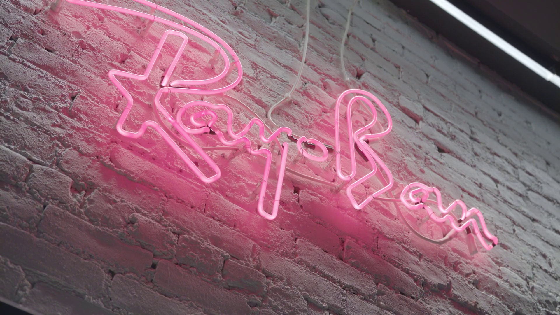Pink neon sign on white brick wall that reads 'Love You' with a heart shape in the middle.