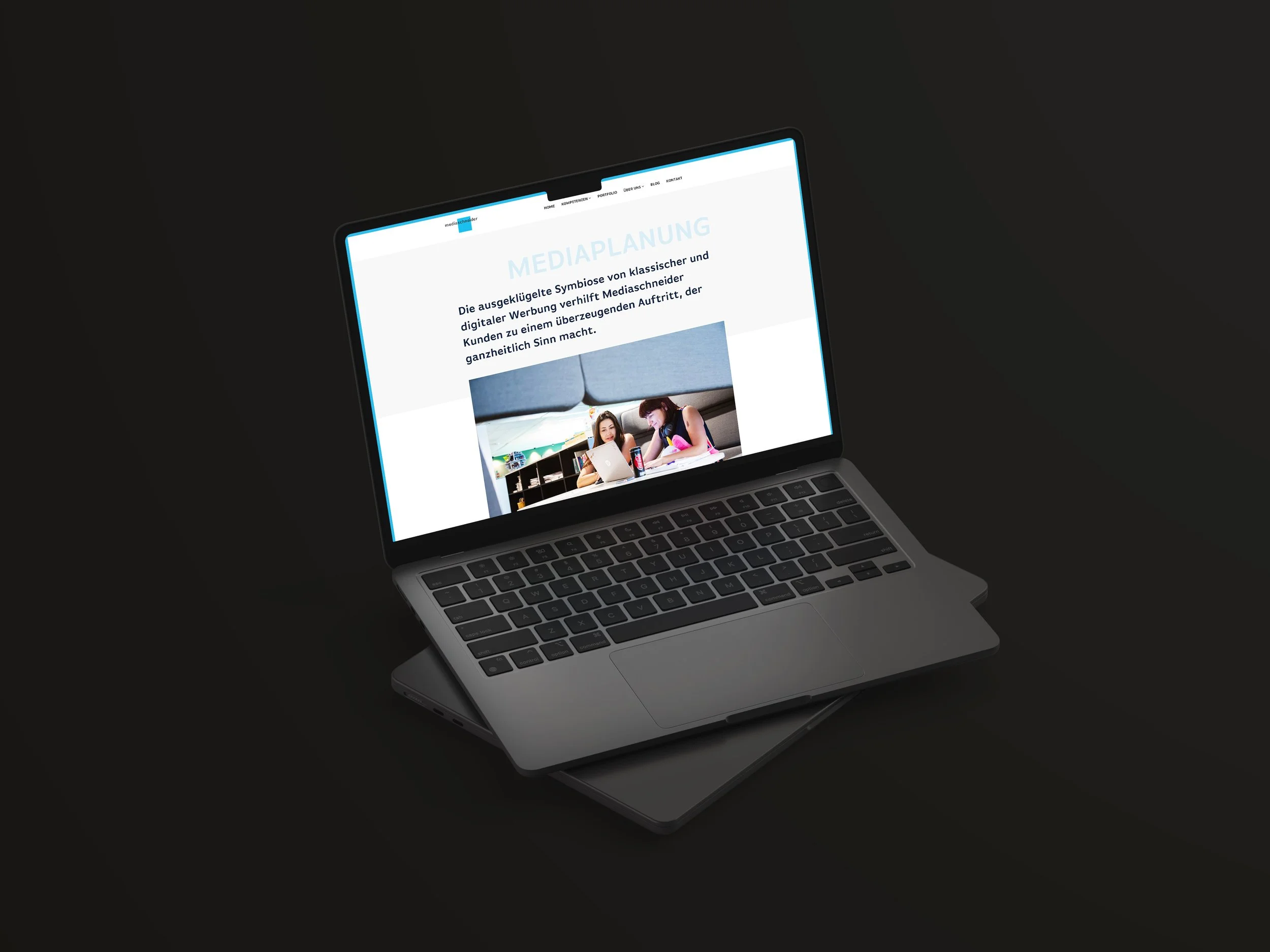 Ein Laptop, der eine Webseite mit dem Titel 'Mediaplanung' anzeigt, liegt auf einem dunklen Hintergrund.