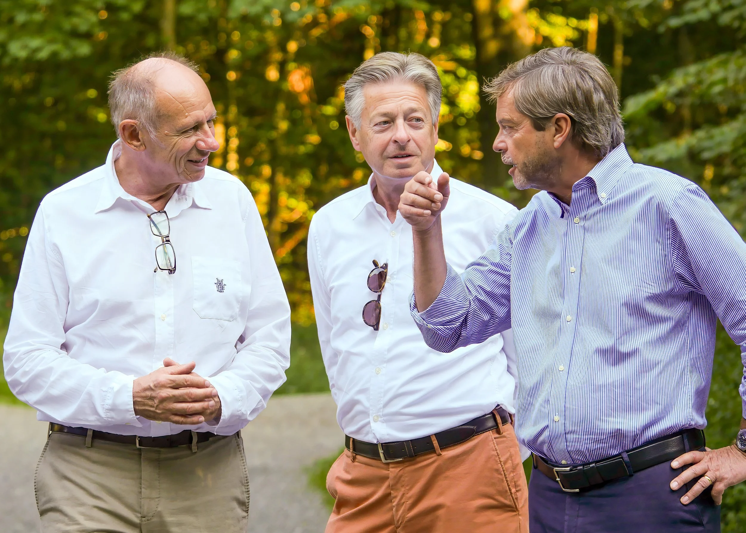 Drei Männer, die sich im Freien unterhalten.