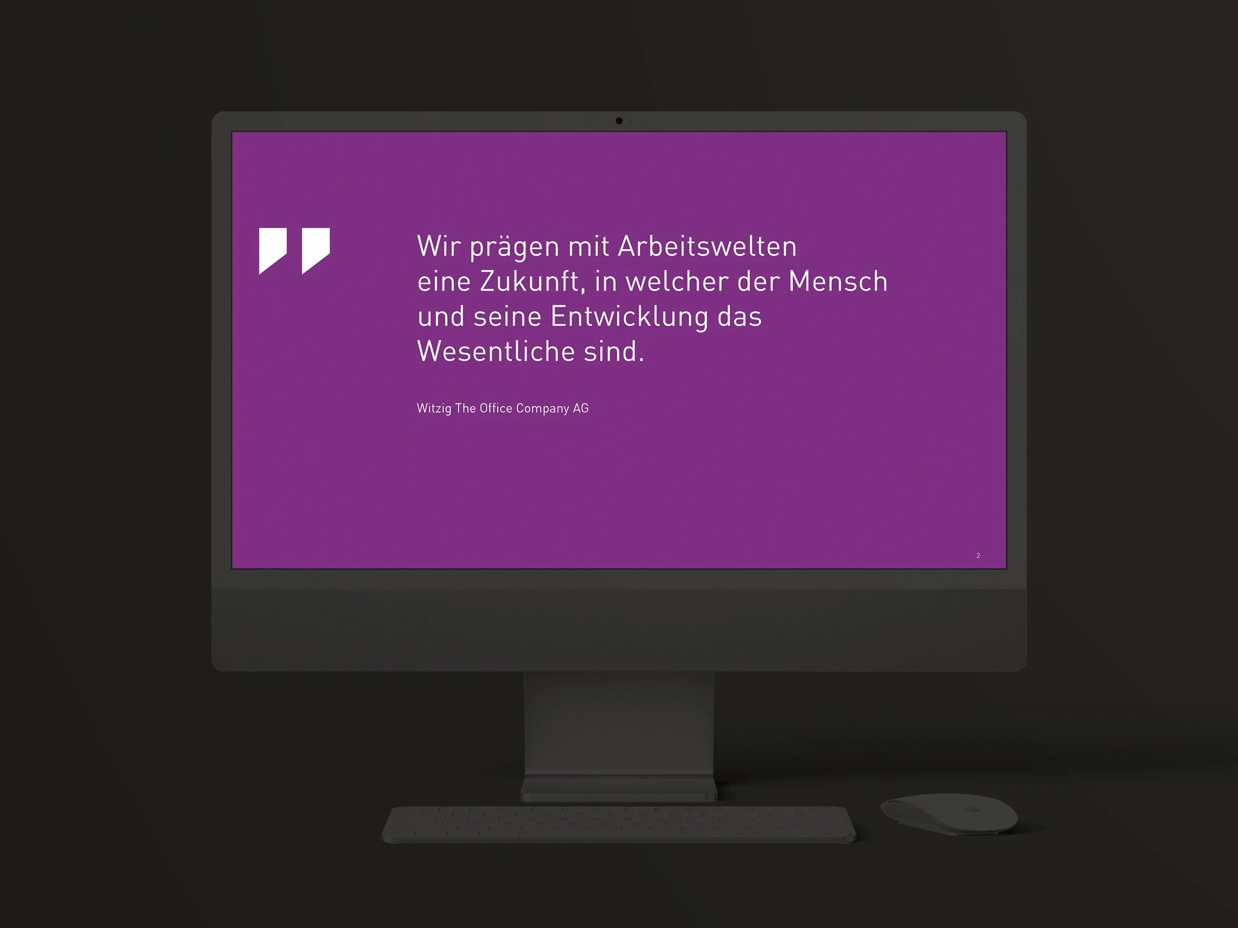 Ein Computerbildschirm mit einem lila Hintergrund und weißen Text in deutscher Sprache. Das Zitat lautet: "Wir prägen mit Arbeitswelten eine Zukunft, in welcher der Mensch und seine Entwicklung das Wesentliche sind."