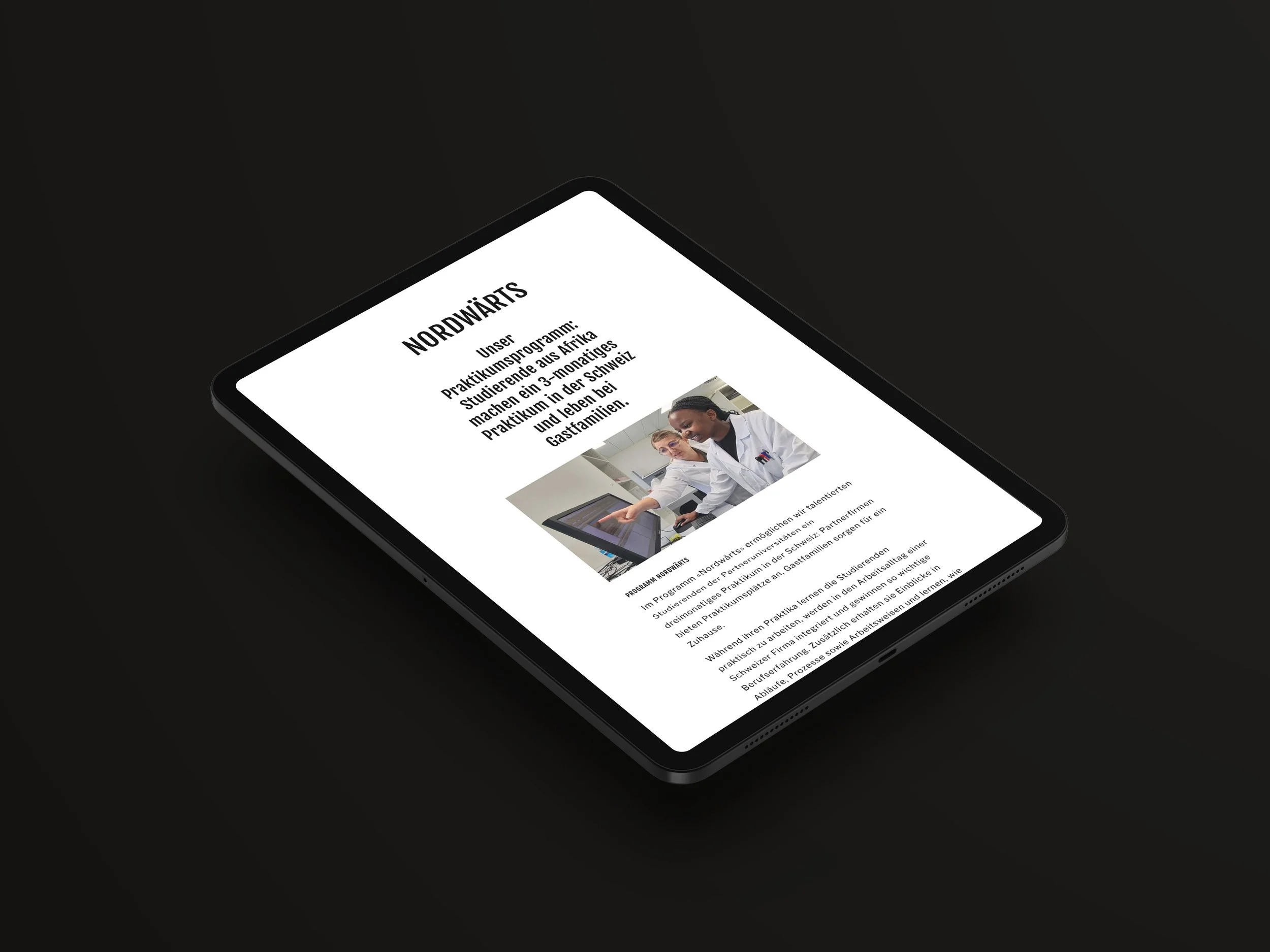 Ein Tablet zeigt eine Webseite über ein Nordwäerts-Praktikumsprogramm mit einem Bild von drei Menschen in weißen Arbeitsanzügen, die an einem Tisch arbeiten.