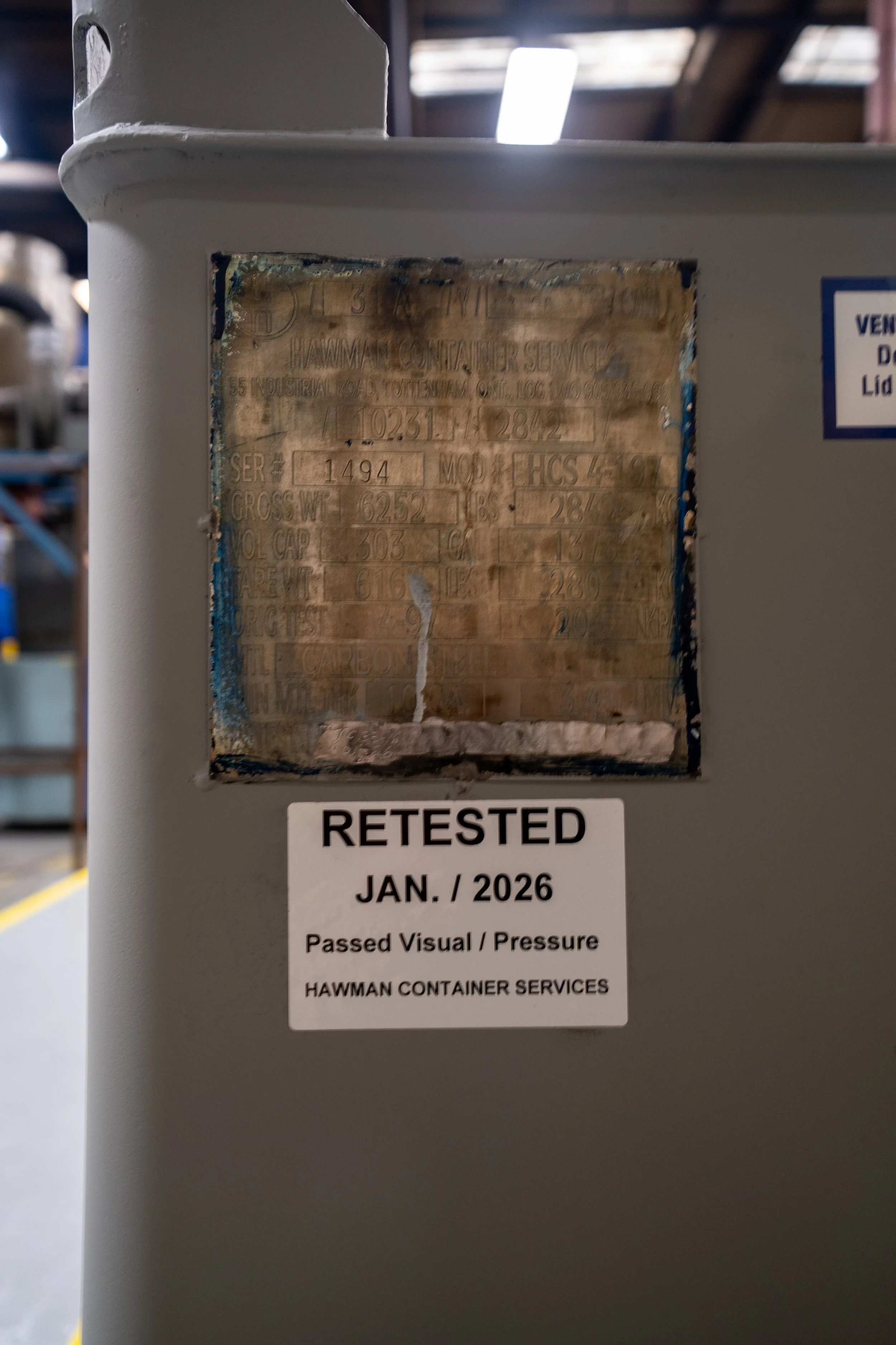 Large gray industrial carbon steel IBC tote tank tested and recertified. IBC Tote Testing, IBC Inspection, IBC Reconditioning & IBC Recertification services by Hawman Container Services.