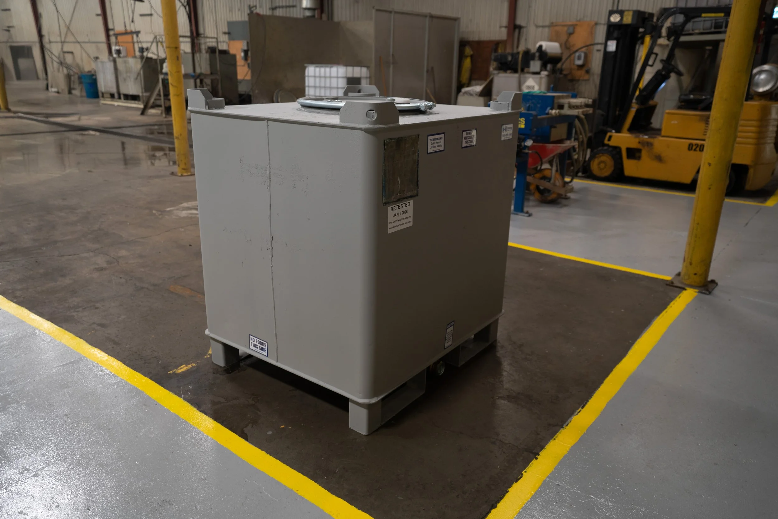 Large gray industrial carbon steel IBC tote tank tested and recertified. IBC Tote Testing, IBC Inspection, IBC Reconditioning & IBC Recertification services by Hawman Container Services.