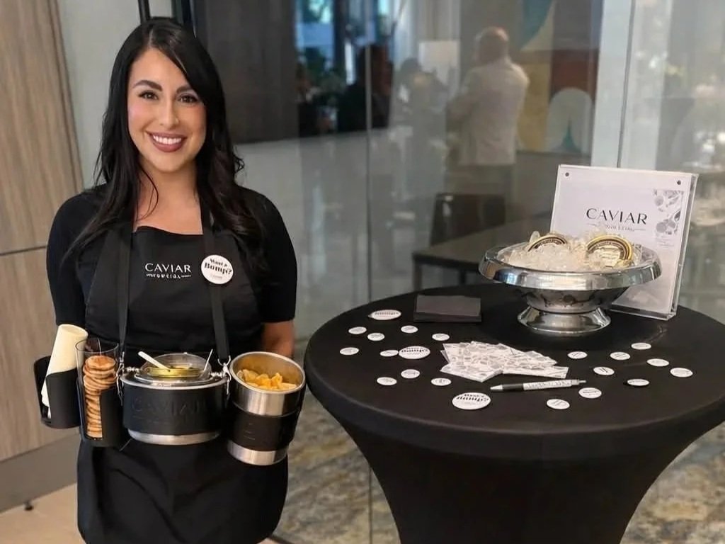 Luxury caviar catering service in St. Petersburg, Florida featuring a server presenting premium caviar tastings with gourmet pairings at a private event.
