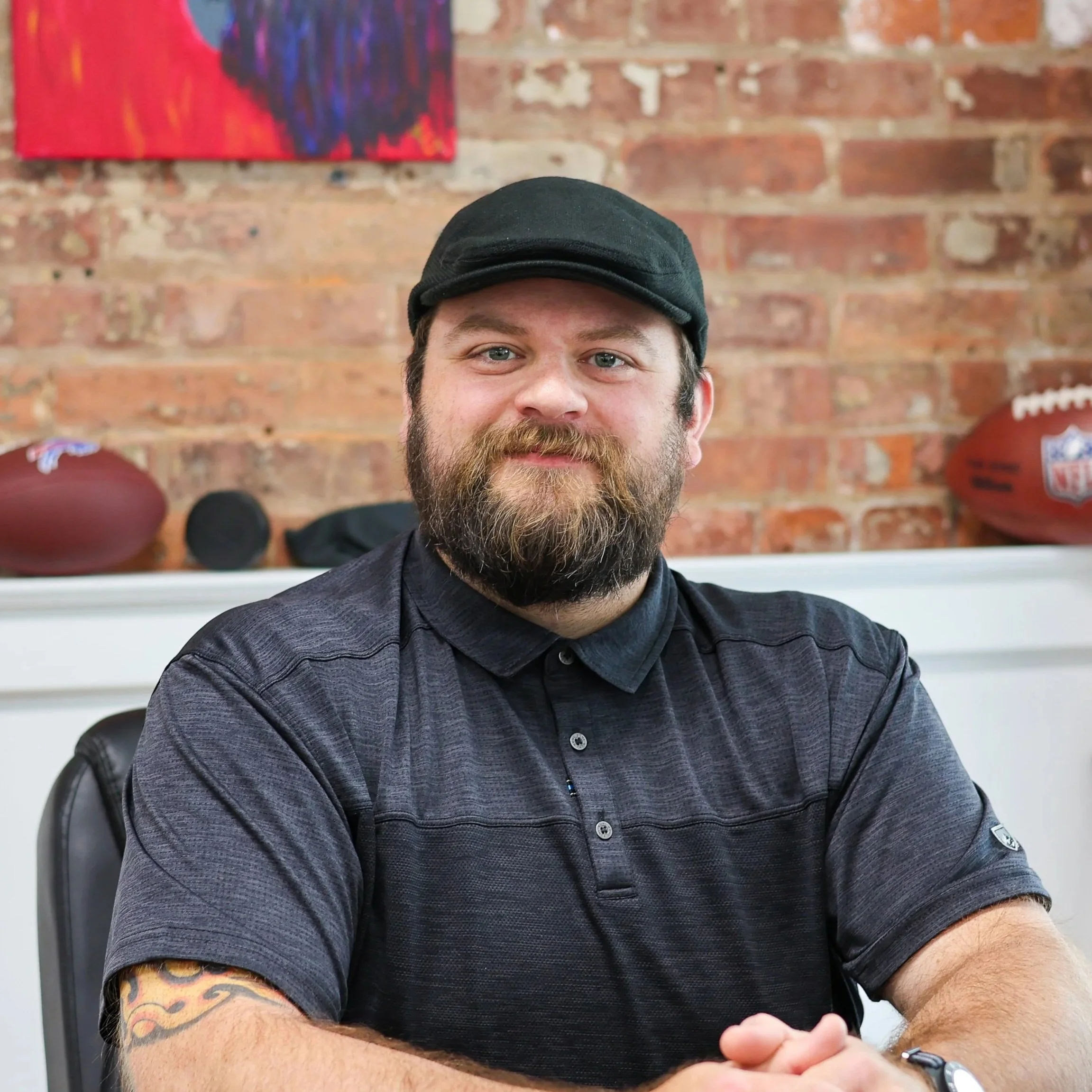 Young man with hat, sitting at desk, smiling
