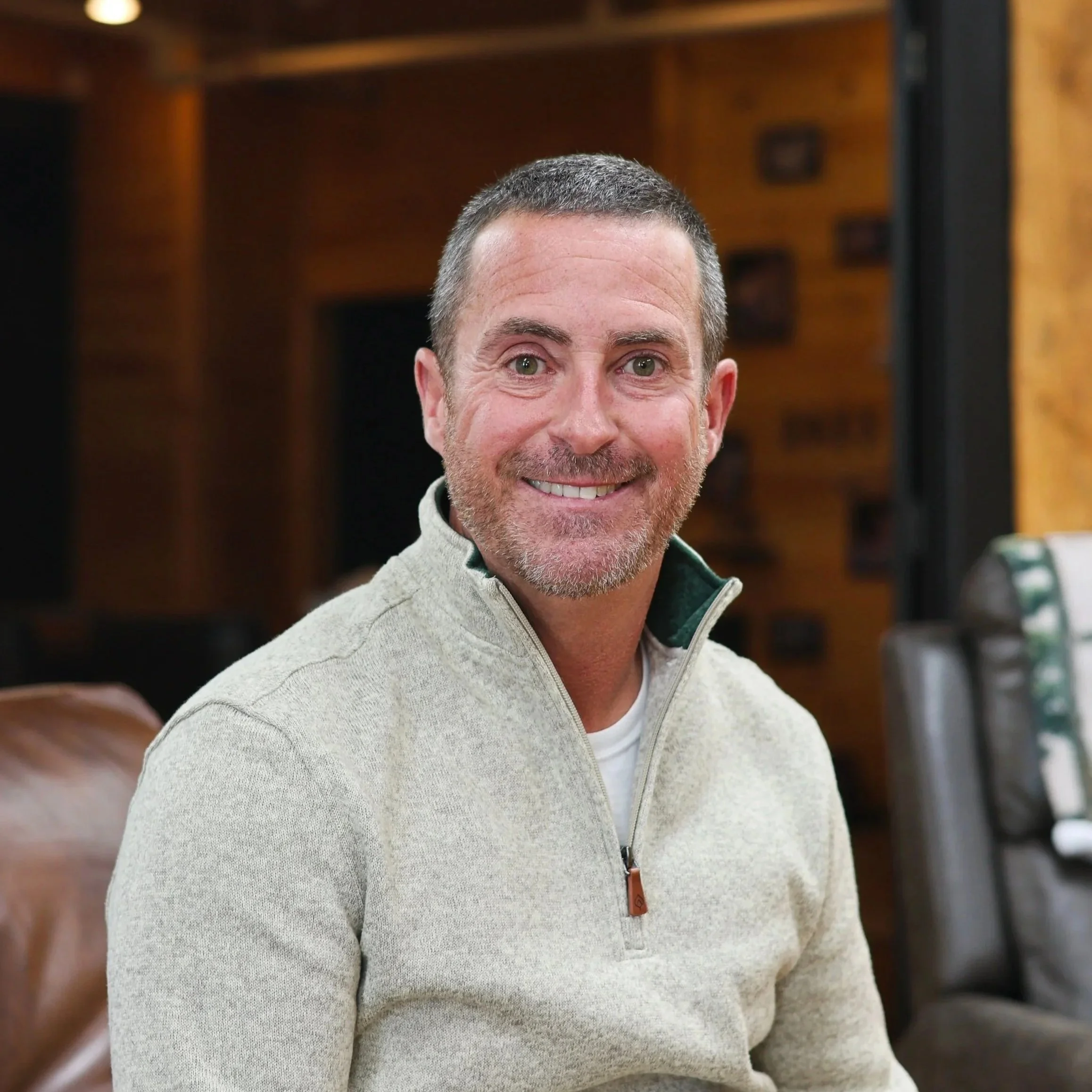 Man in quarter-zip with short hair smiling for a staff photo.