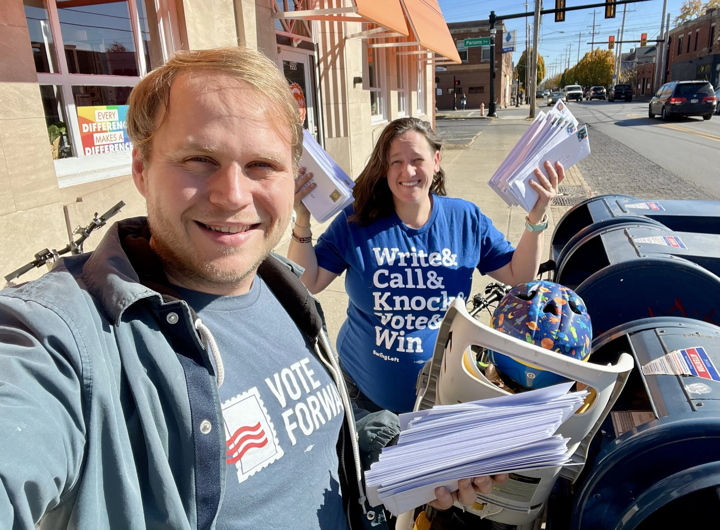 Two volunteers ready to mail their Vote Forward letters on a sunny day.