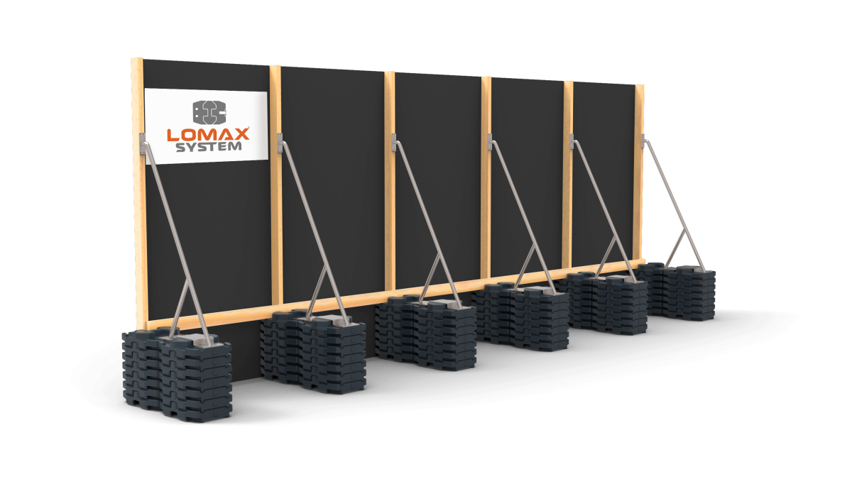 A display of portable black weight plates stacked in pairs, with wooden framing and black boards showcasing the logo 'LOMAX SYSTEM' for strength training equipment or gym setup.