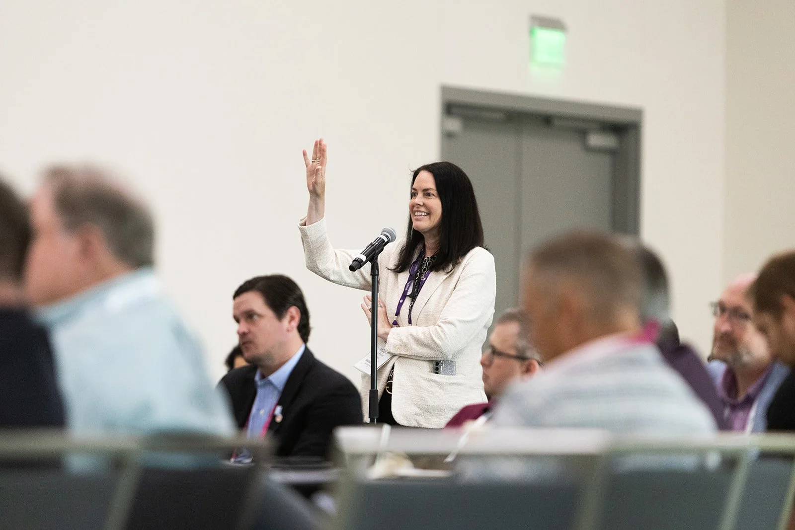 Convention in San Diego. Woman raises hand to ask a question.