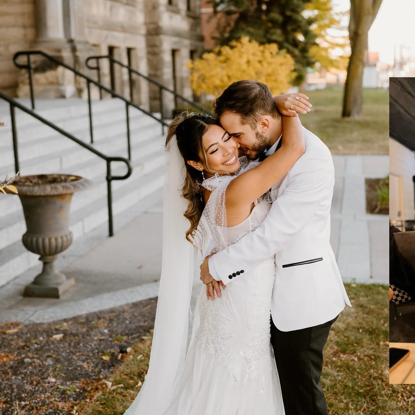 A bride and groom sharing a joyful embrace outside during fall, smiling with their eyes closed, with autumn trees and a stone building in the background.