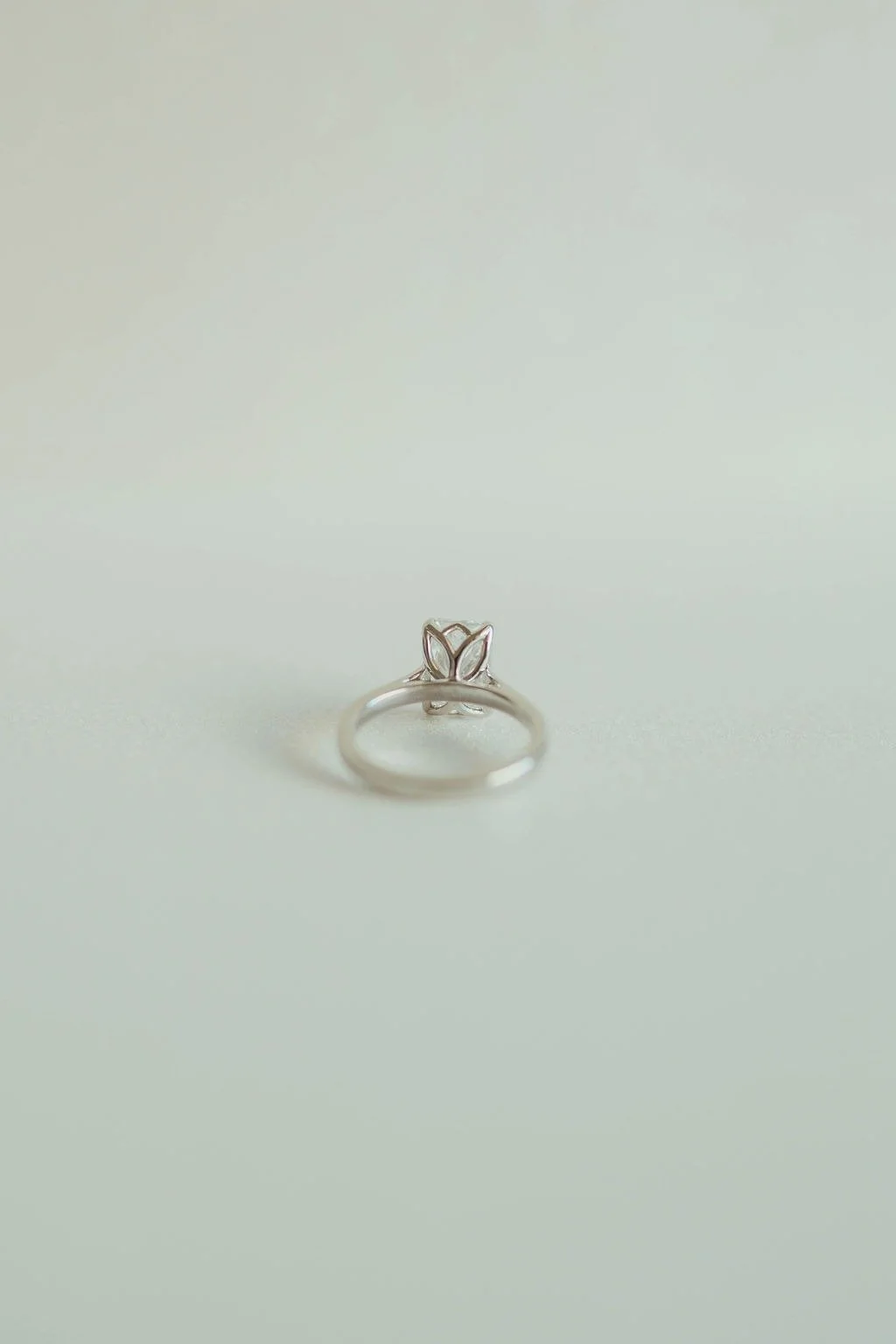 A silver ring with a butterfly design on a light-colored surface.