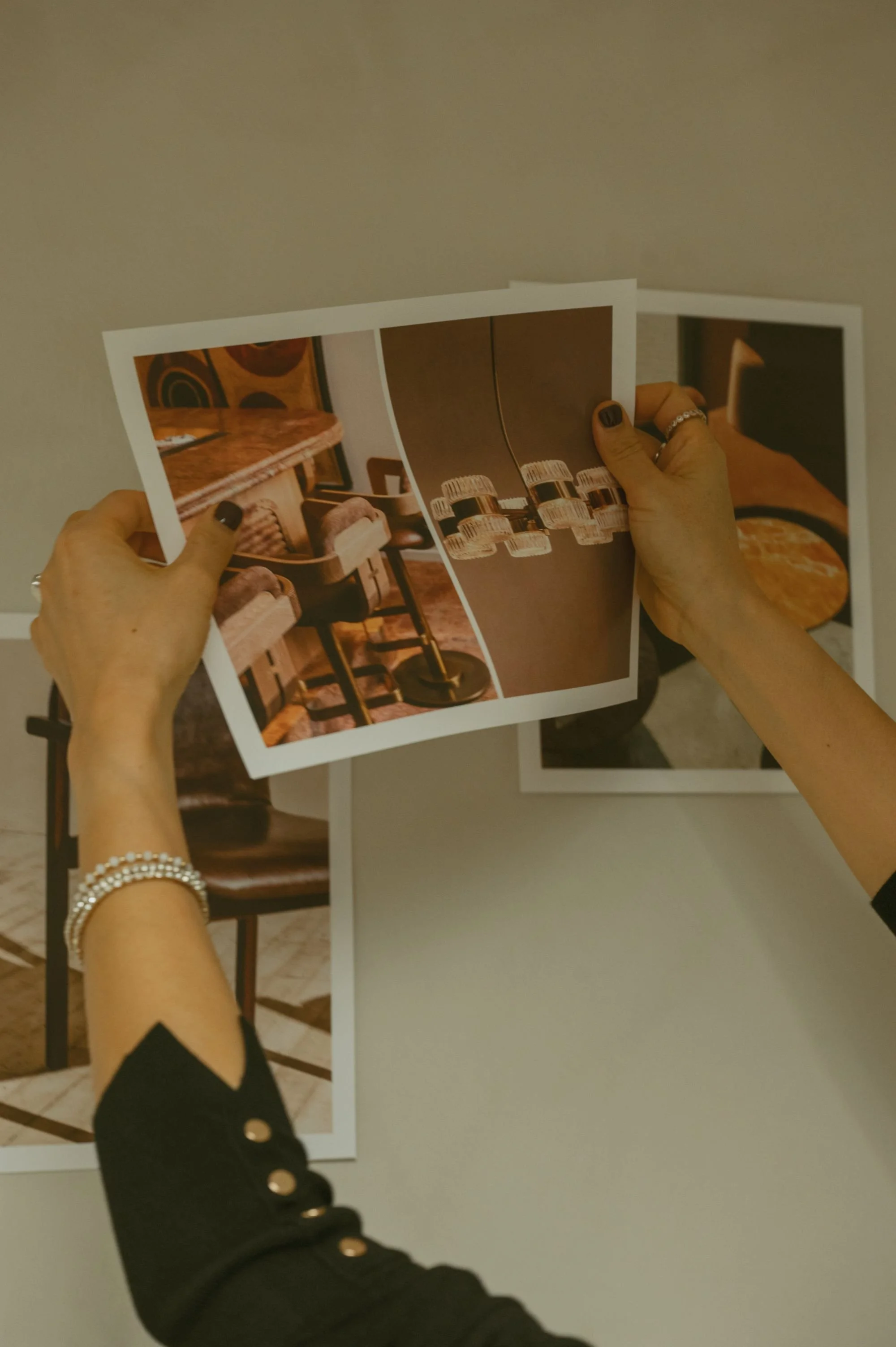 Interior designer curating a mood board with magazine clippings and design inspiration photos.