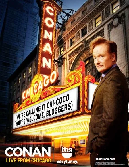A promotional poster for the TV show 'Conan,' featuring Conan O'Brien standing in front of the Chicago Theatre marquee with bright lights and a cityscape background.
